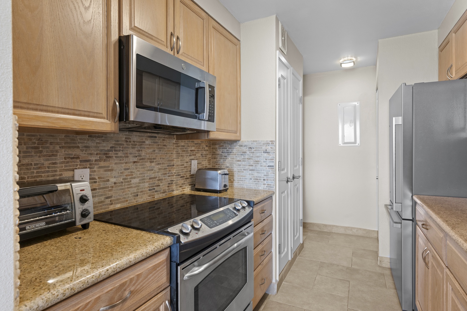 Your fully equipped galley kitchen offers granite counters, stainless appliances, and stone backsplash—perfect for preparing meals during your stay.