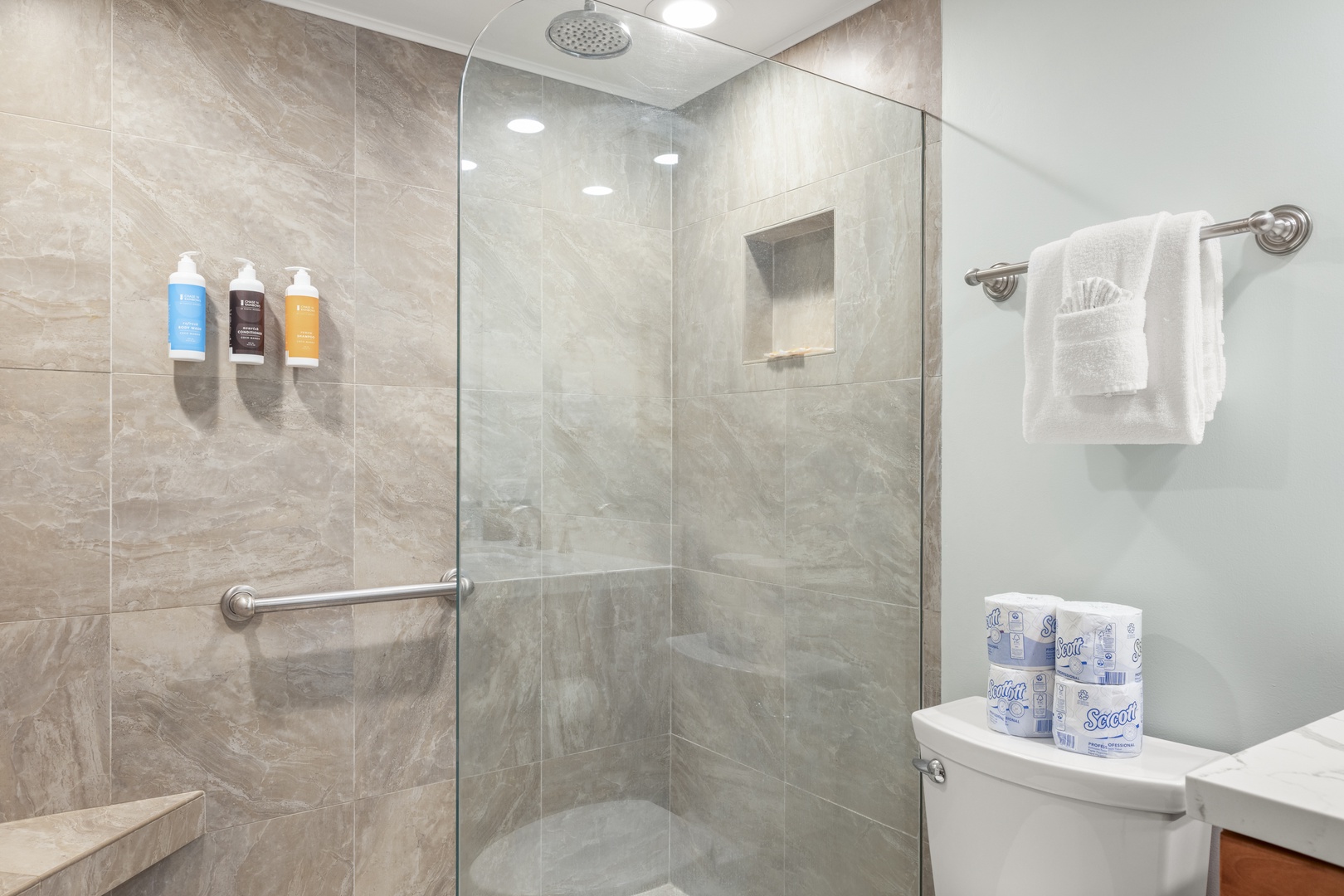 Step into your spotless marble-tiled bathroom with a spacious walk-in shower, rainfall showerhead, and safety grab bars. Fluffy towels await you after a refreshing rinse.