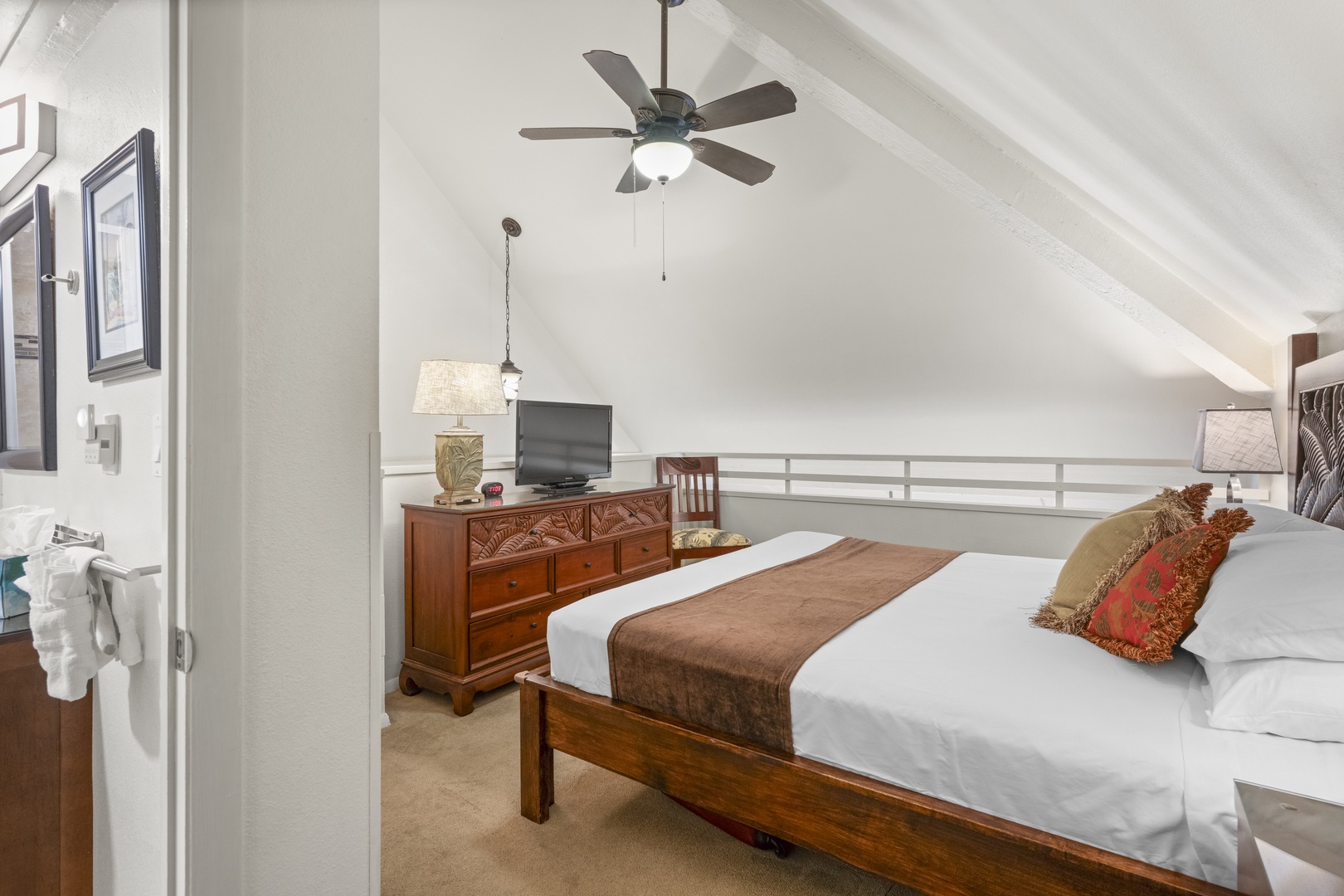 Your peaceful upstairs retreat features vaulted ceilings, a plush bed dressed in crisp linens, charming tropical accents, and a private en-suite—perfect for restful nights.