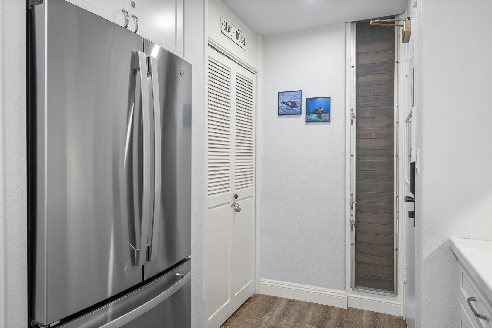Bright hallway leads you to a modern kitchen complete with stainless steel appliances and sleek finishes. Everything you need for convenient meal prep is right here.