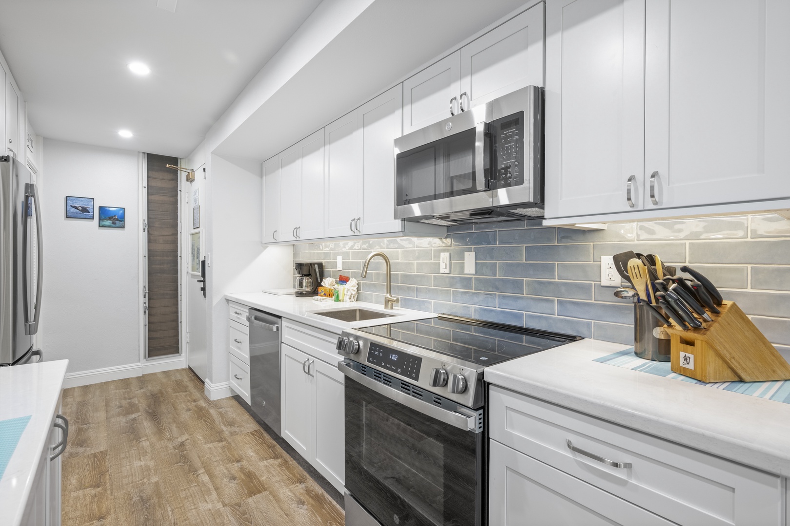 Step into your bright, fully equipped kitchen where gleaming white cabinetry and sleek stainless appliances await. Every detail is designed to make meal prep a breeze.