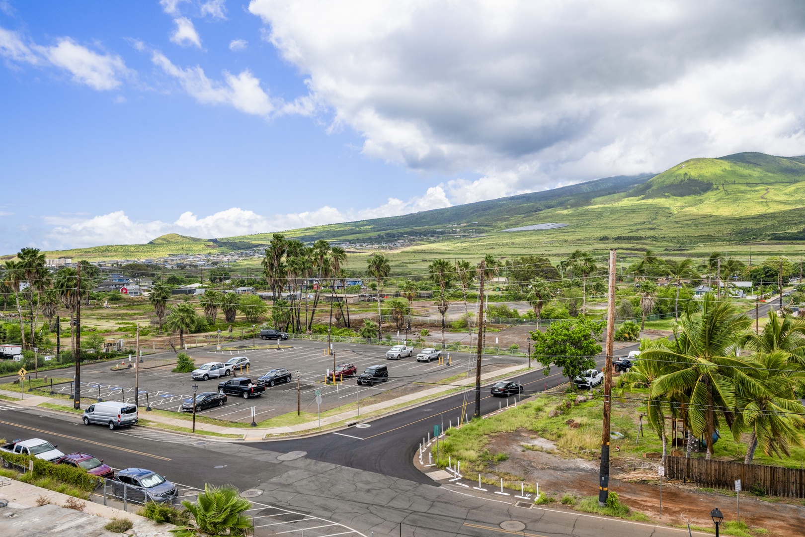 This property is situated in a tropical landscape with rolling green mountains, palm trees, and easy access to local roads and surrounding neighborhoods.