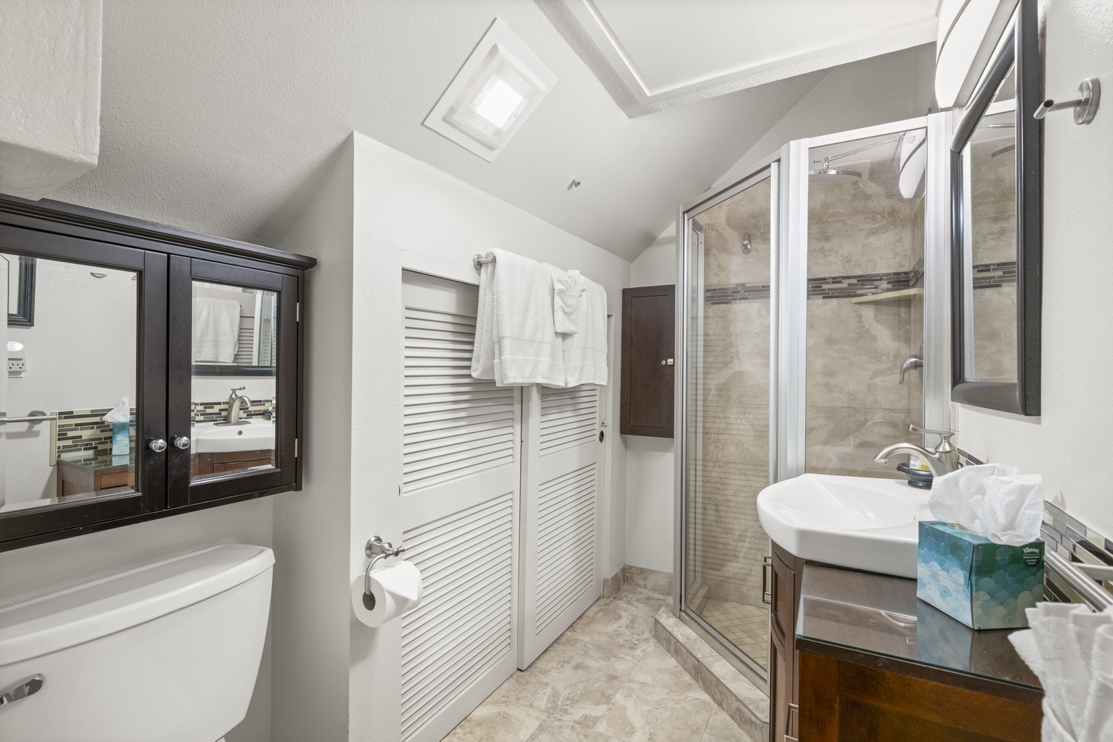 Step into your private spa-like bathroom, where a spacious walk-in shower, gleaming fixtures, and fresh towels await your arrival after a day of adventure.