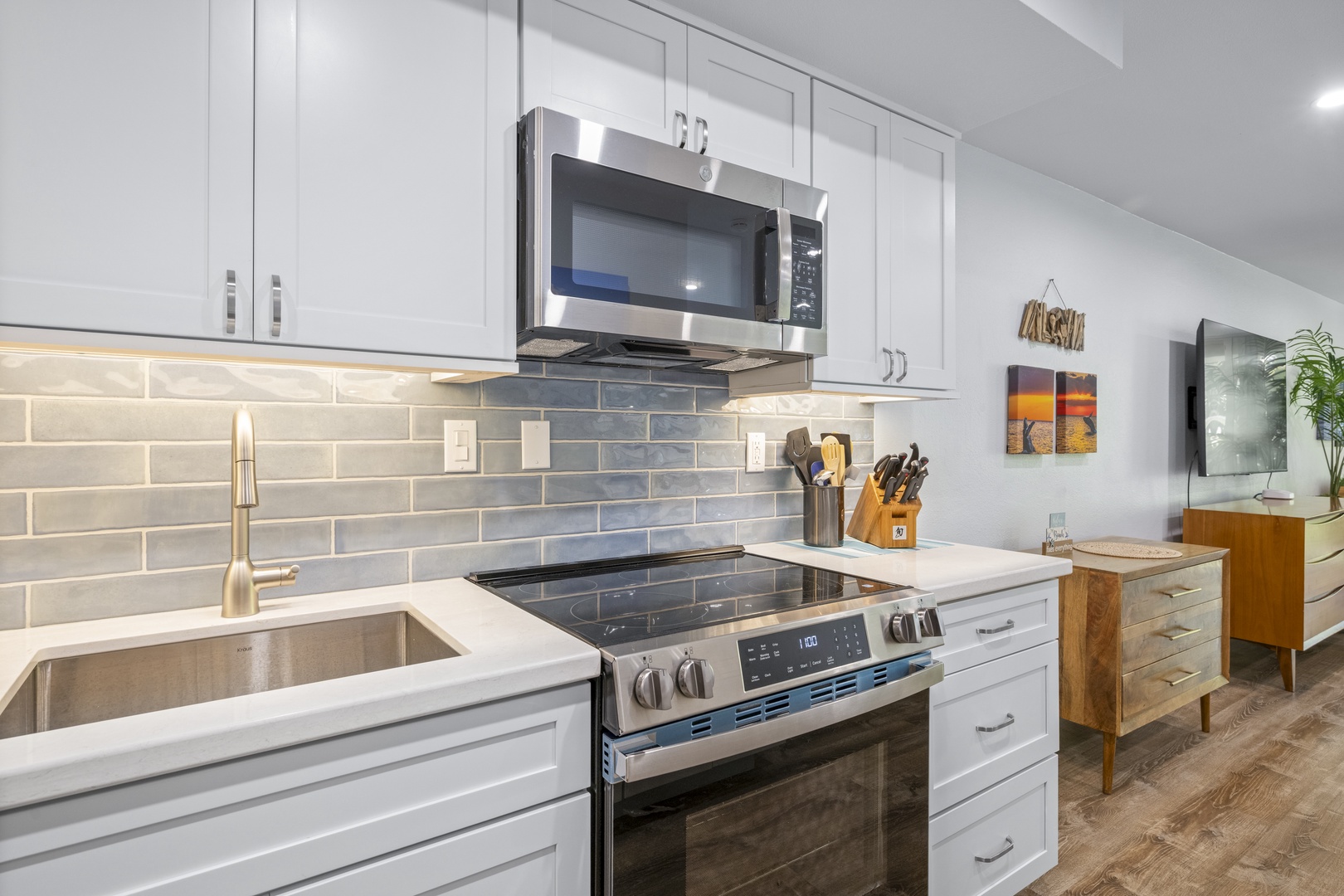 Step into your sleek, modern kitchen with gleaming white cabinetry, stainless steel appliances, and elegant tile backsplash ready for your culinary creations.