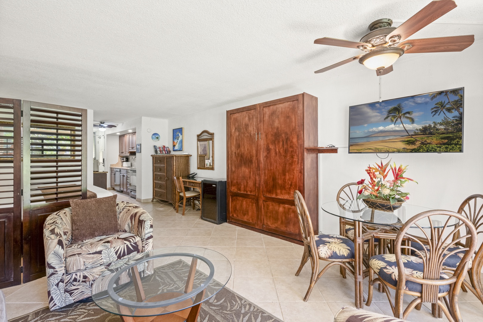 Relax in your tropical-inspired living and dining space featuring open layout, ceiling fans for comfort, island décor, and convenient access to the kitchen—perfect for unwinding after beach adventures.