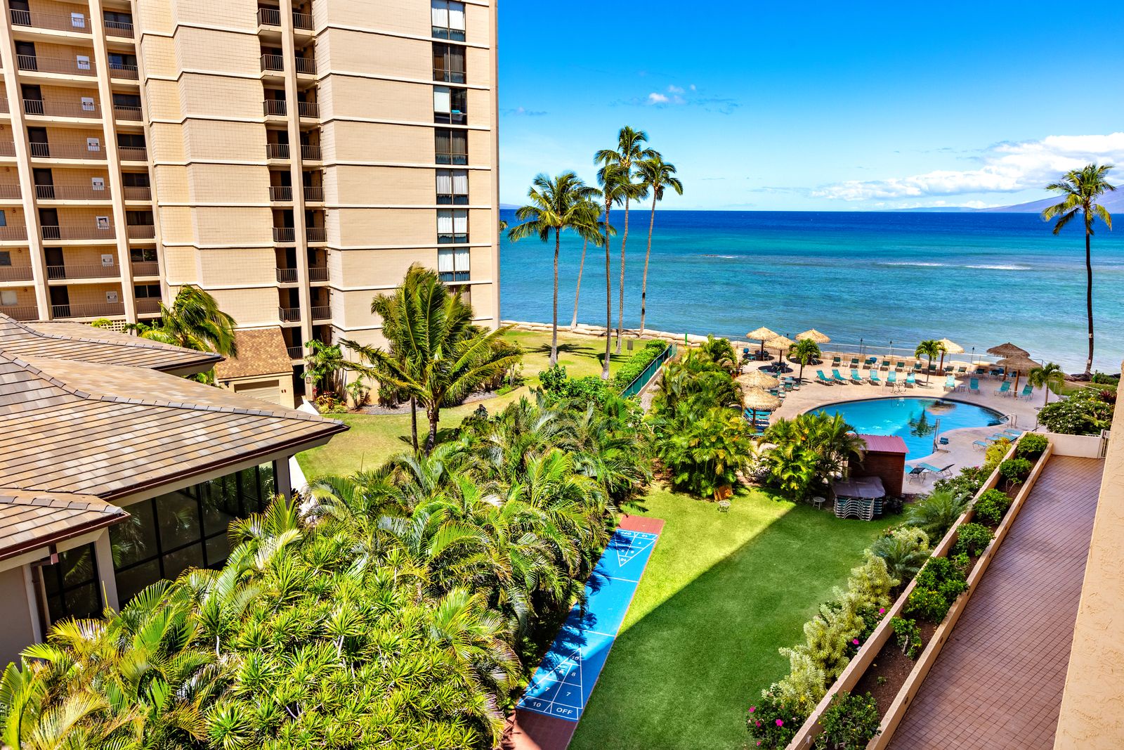 Tropical paradise resort with oceanfront pools, lush gardens, and pristine beaches beneath swaying palms and brilliant blue skies.