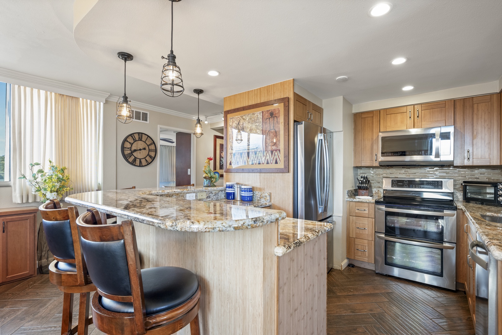 Bright, stylish kitchen featuring a spacious granite island, stainless appliances, and warm wood cabinetry. Pendant lights and natural light make it perfect for cooking, entertaining, and morning coffee.