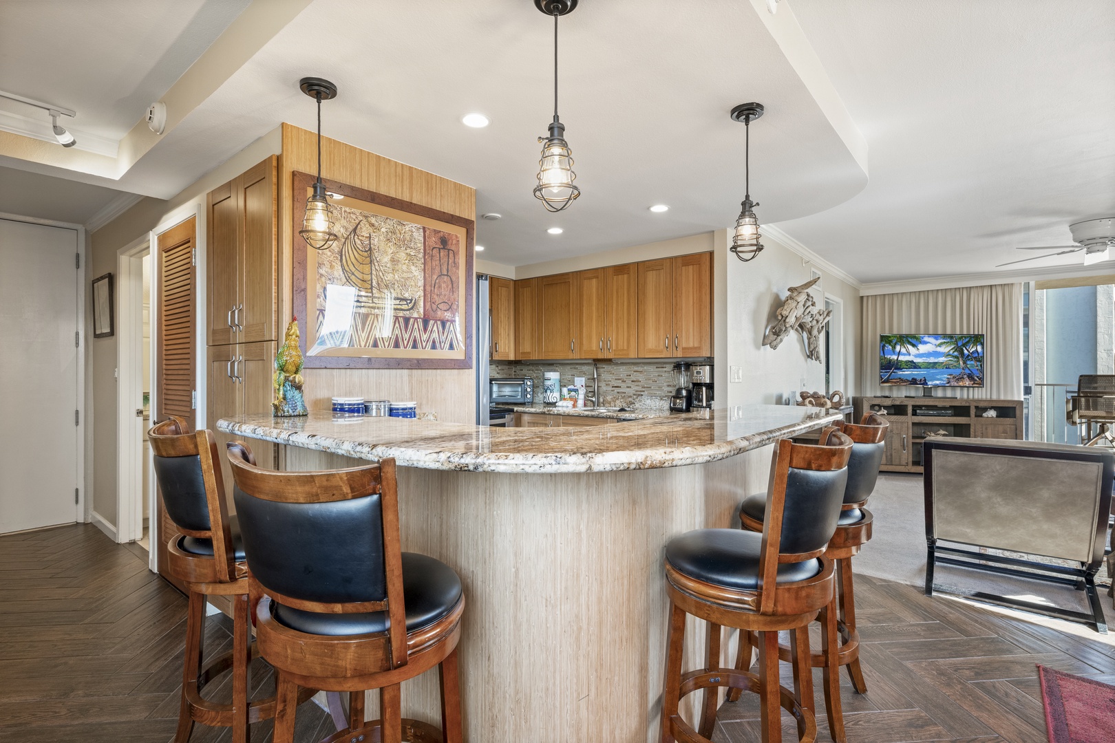 Gather at the curved breakfast bar with granite counters and warm wood tones, where industrial pendant lighting sets a welcoming vibe for your morning coffee or evening cocktails together.