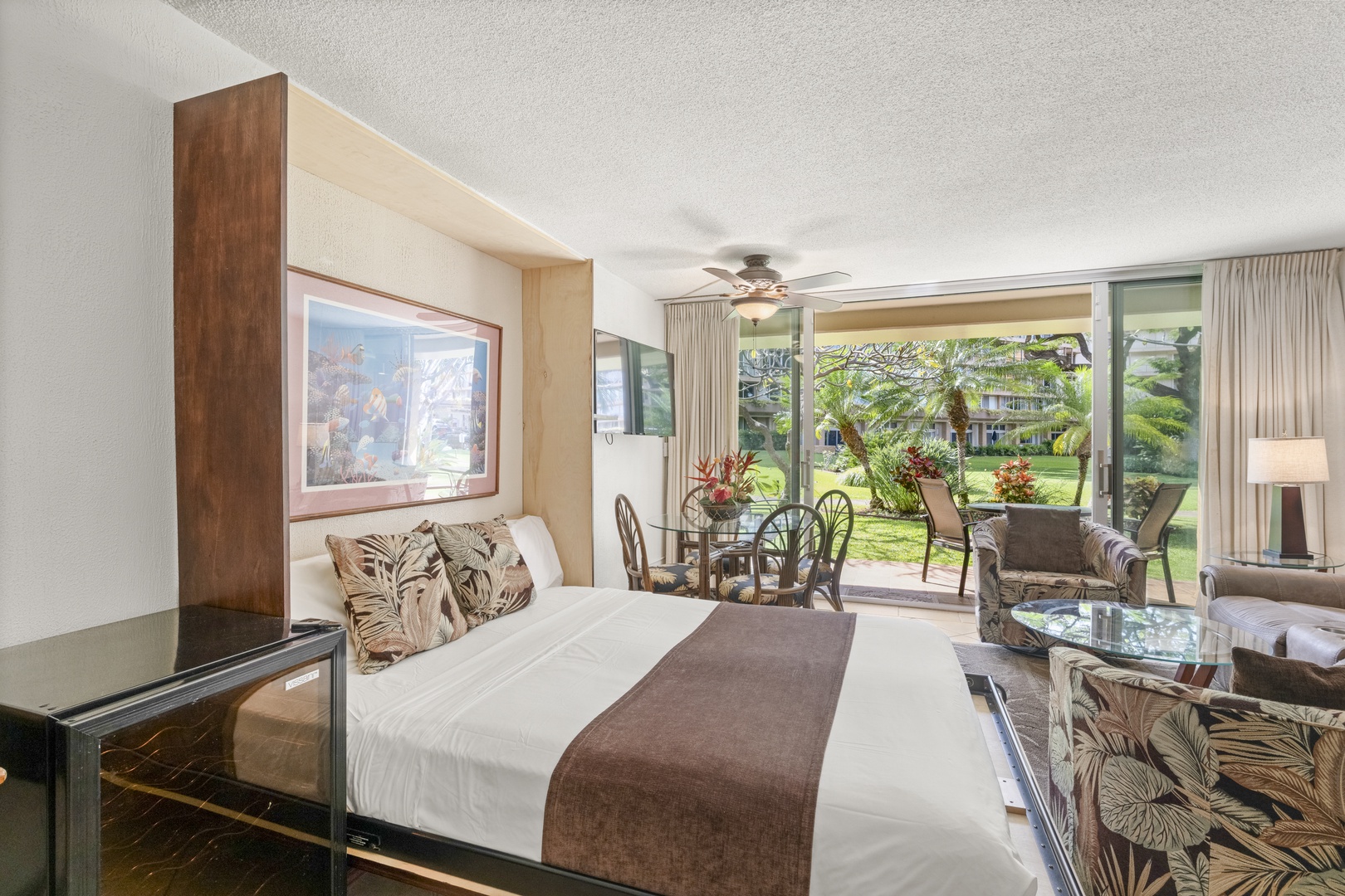 Step into your tropical retreat where lush garden views greet you from floor-to-ceiling windows. Relax on plush island-inspired seating or unwind on your private patio surrounded by swaying palms.