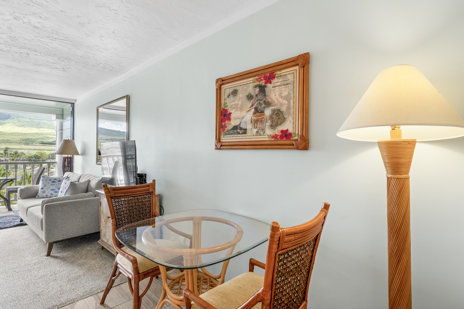 Relax at the glass-top dining table, where tropical rattan chairs and warm lamp light invite you to share meals with sweeping views of the lush valley beyond.