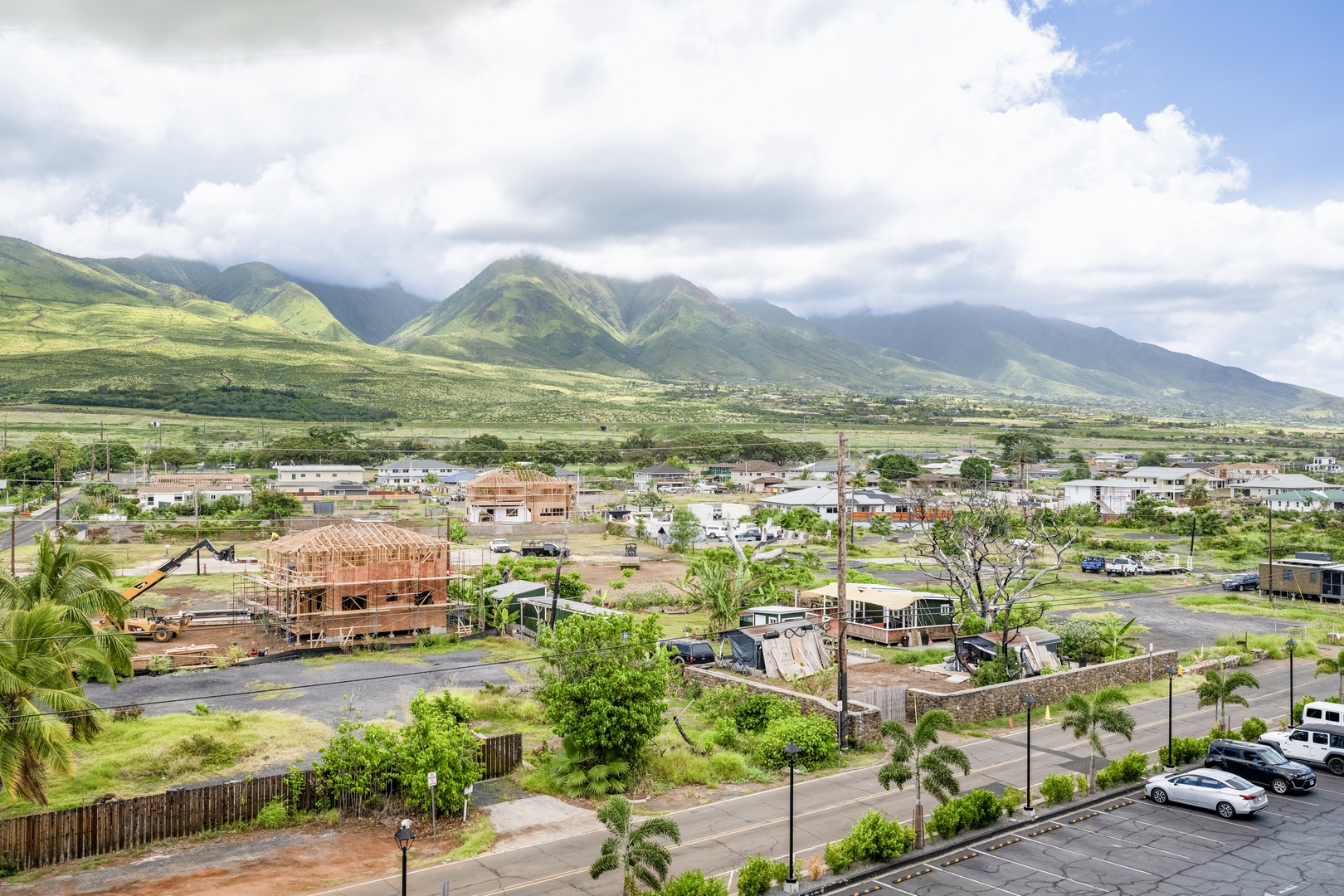 Lush mountain views and residential neighborhood with green valleys stretching across the landscape. The dramatic peaks and open skies create a stunning natural backdrop.