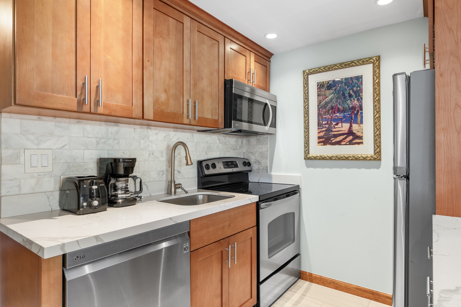 Your fully equipped kitchen features marble countertops, stainless steel appliances, and warm wood cabinetry—everything you need to prepare meals in comfort during your stay.