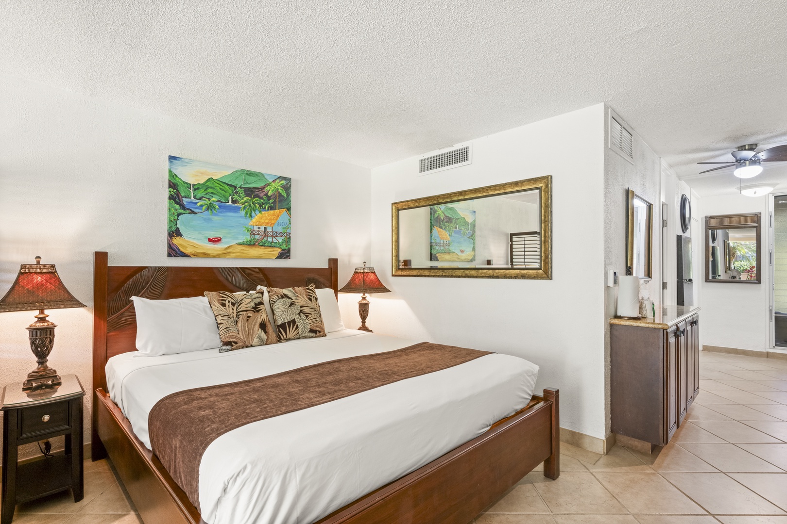 Sink into crisp white linens and unwind in your tropical-themed bedroom, where island artwork sets the scene for your relaxing getaway. You'll love the cozy lighting and refreshing cool air from your private air conditioning.