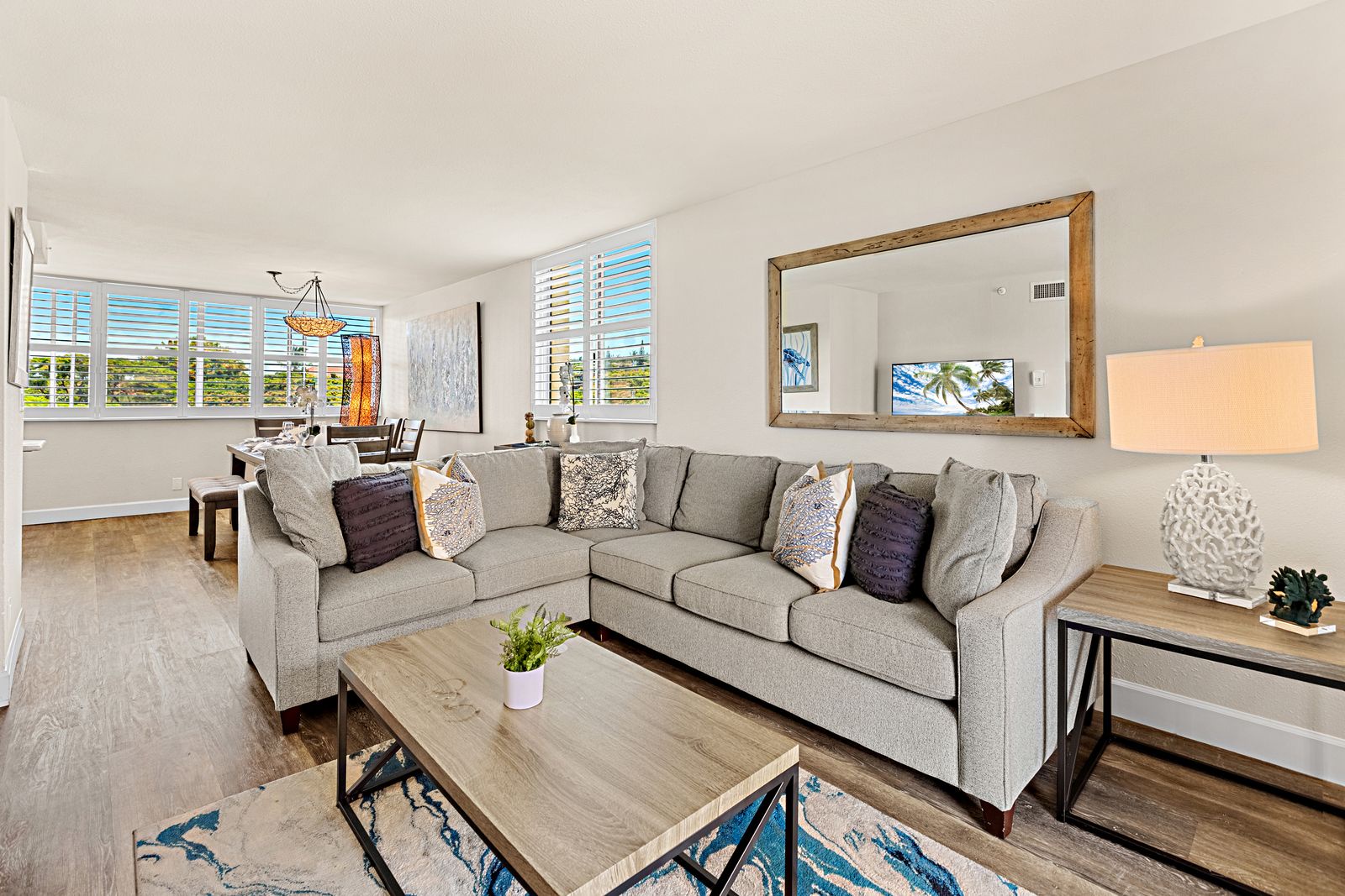 Unwind in your bright, modern living space with plush seating and natural light streaming through plantation shutters.