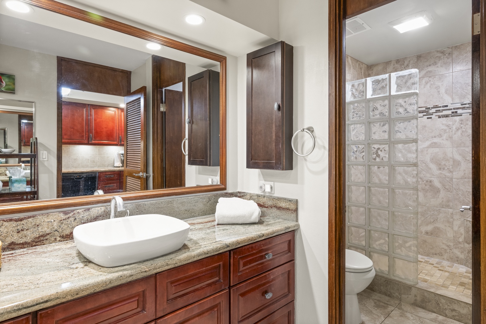 Refresh in this elegant bathroom with a spacious granite vanity, modern vessel sink, and a walk-in shower with beautiful tiled walls. Everything you need for a comfortable stay is within easy reach.