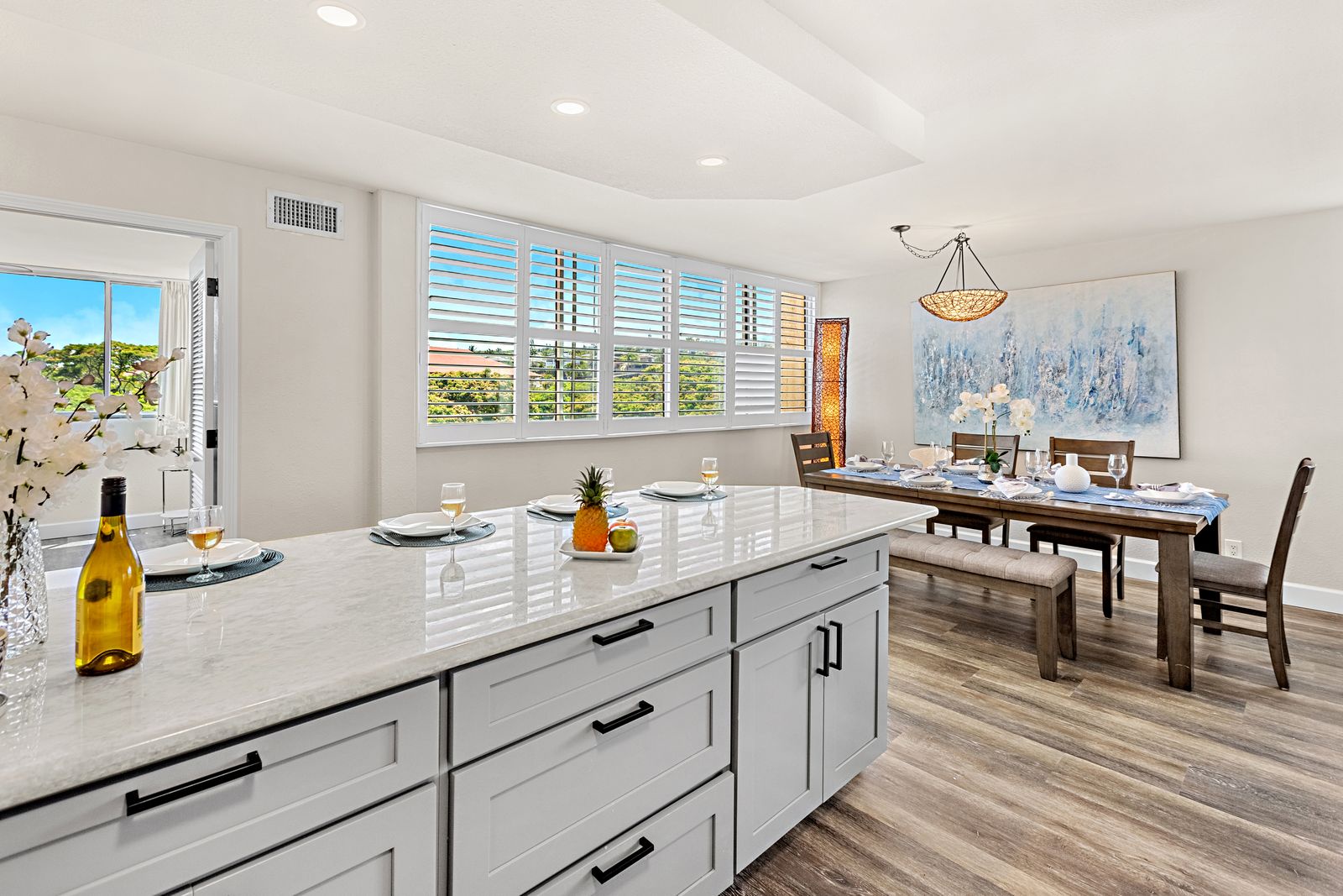 Your modern kitchen flows seamlessly into the dining area, where natural light streams through plantation shutters as you prepare meals and gather for memorable dinners.