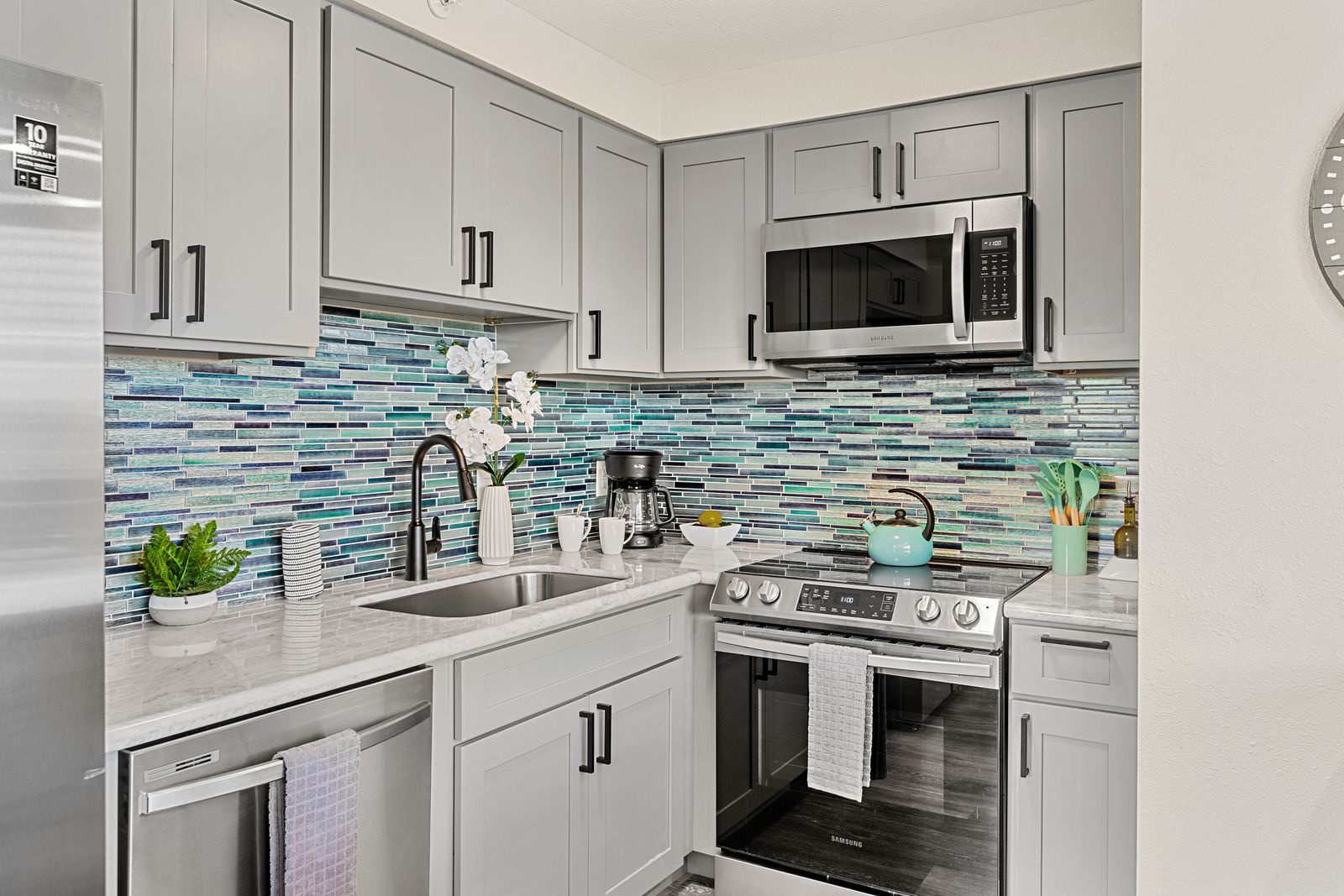 You'll love preparing meals in this stylish kitchen featuring modern appliances and stunning ocean-inspired tile backsplash.