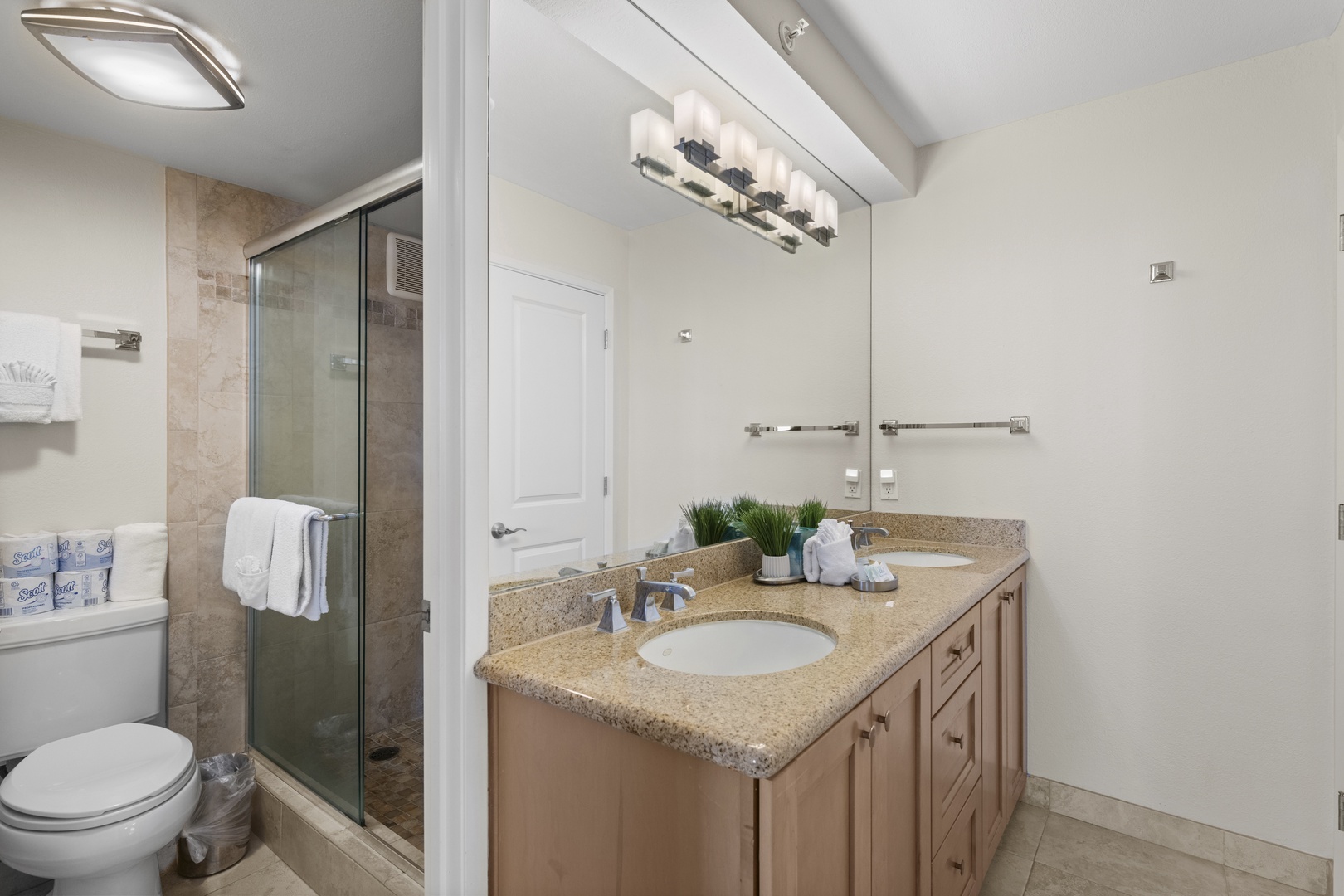Your stylish bathroom features granite countertops, modern fixtures, and a spacious glass shower for ultimate comfort.
