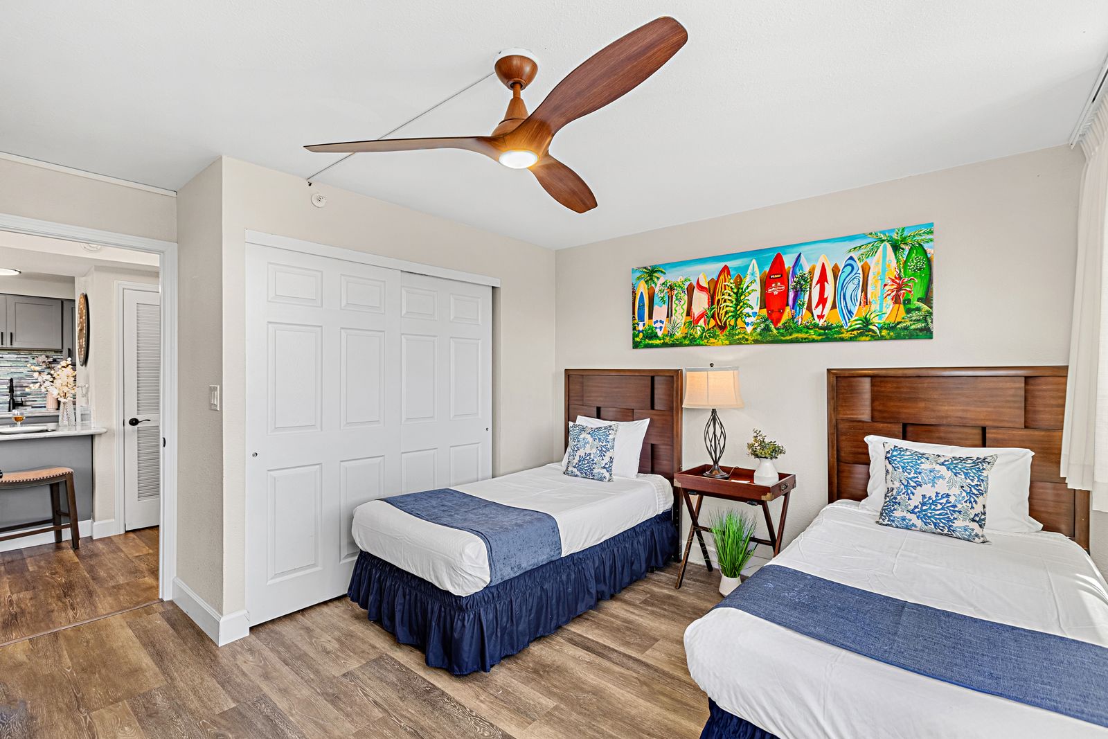 Sleep peacefully in your tropical-themed bedroom with twin beds, warm wood headboards, and cheerful surfboard art that sets the perfect vacation mood.