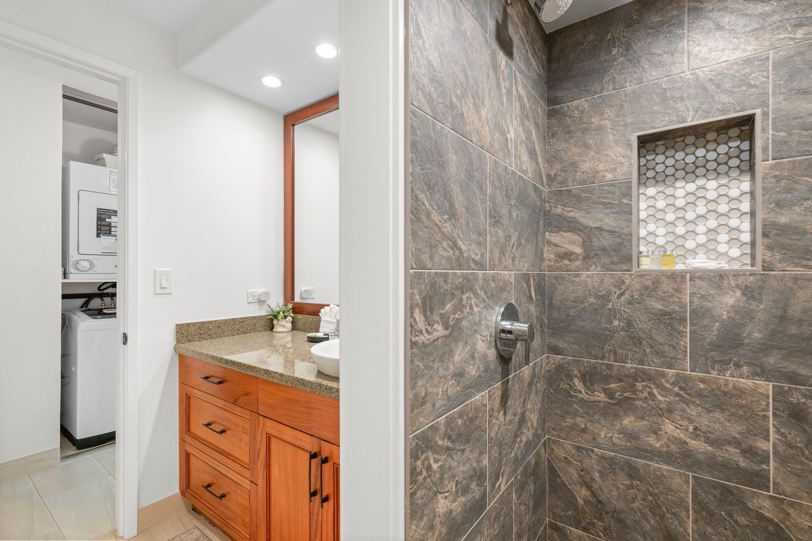 Step into your beautifully updated bathroom with elegant slate-toned tile work, a spacious walk-in shower, and stylish cabinetry waiting to refresh you after your day's adventures.