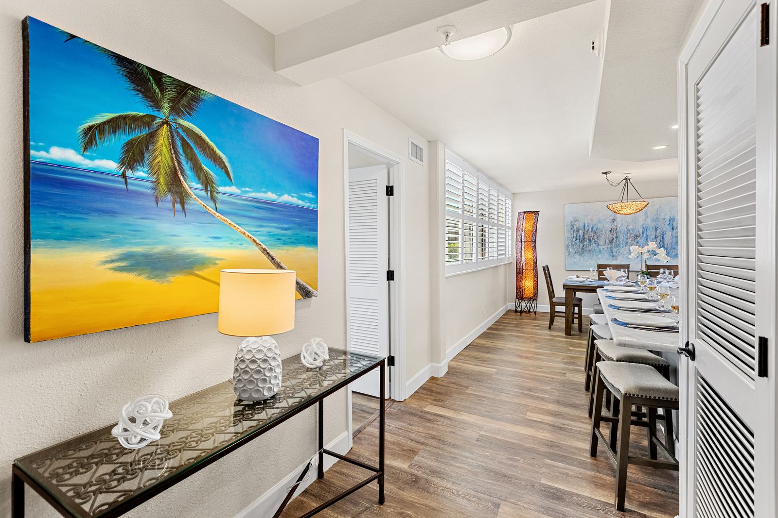 Tropical artwork sets the mood as you enter your bright, coastal-inspired space with elegant dining and thoughtful details throughout.