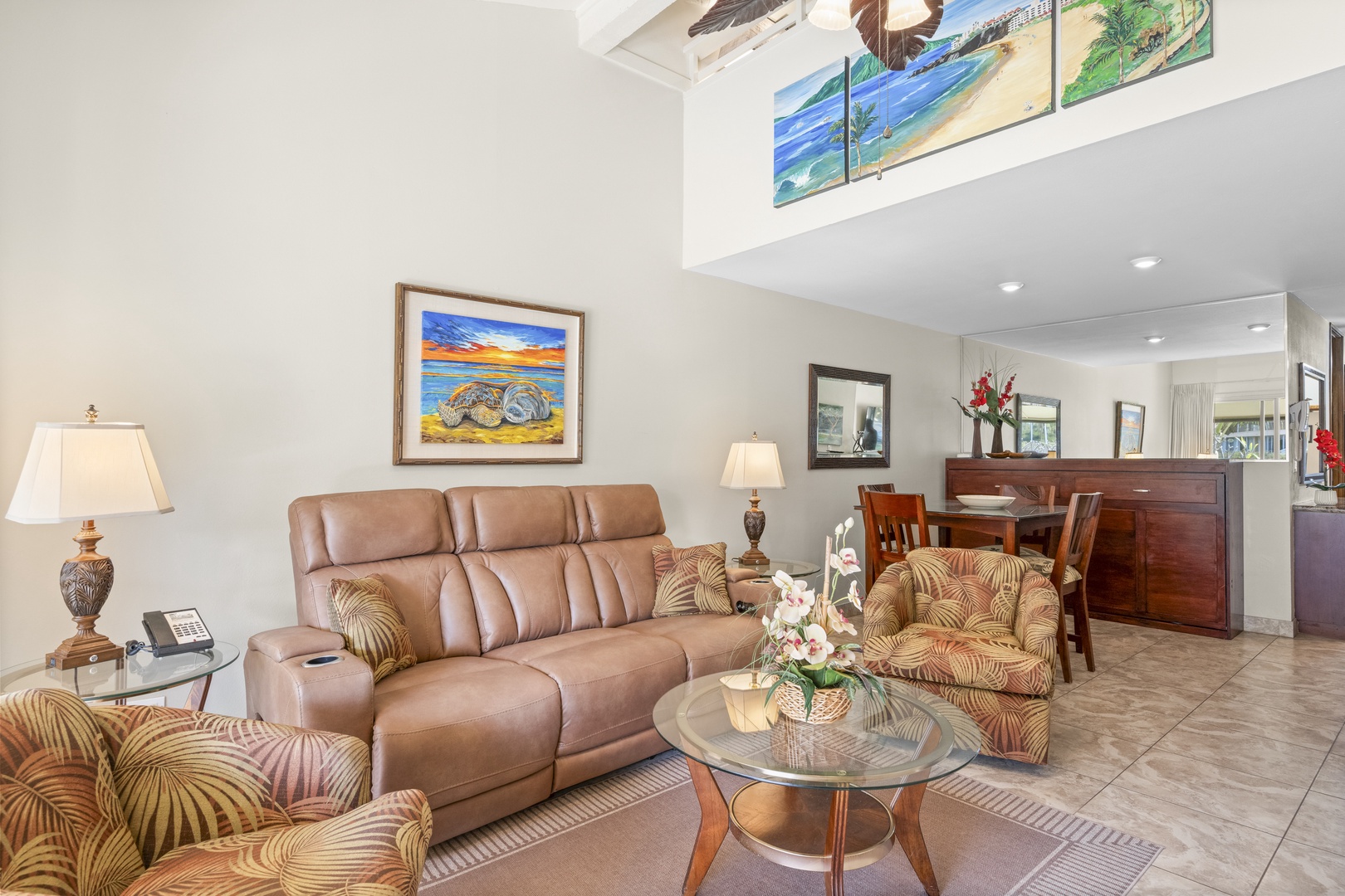 Relax in this bright, open living space with comfortable seating, beach-themed art, and a loft-style design that invites you to unwind in tropical-inspired surroundings.