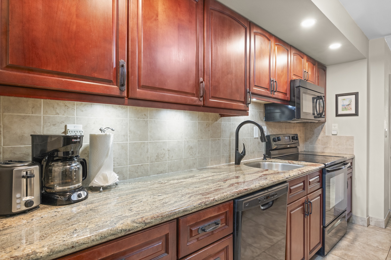 Your fully equipped kitchen features elegant granite countertops, rich wood cabinetry, and modern appliances, making it easy to prepare meals just the way you like them.
