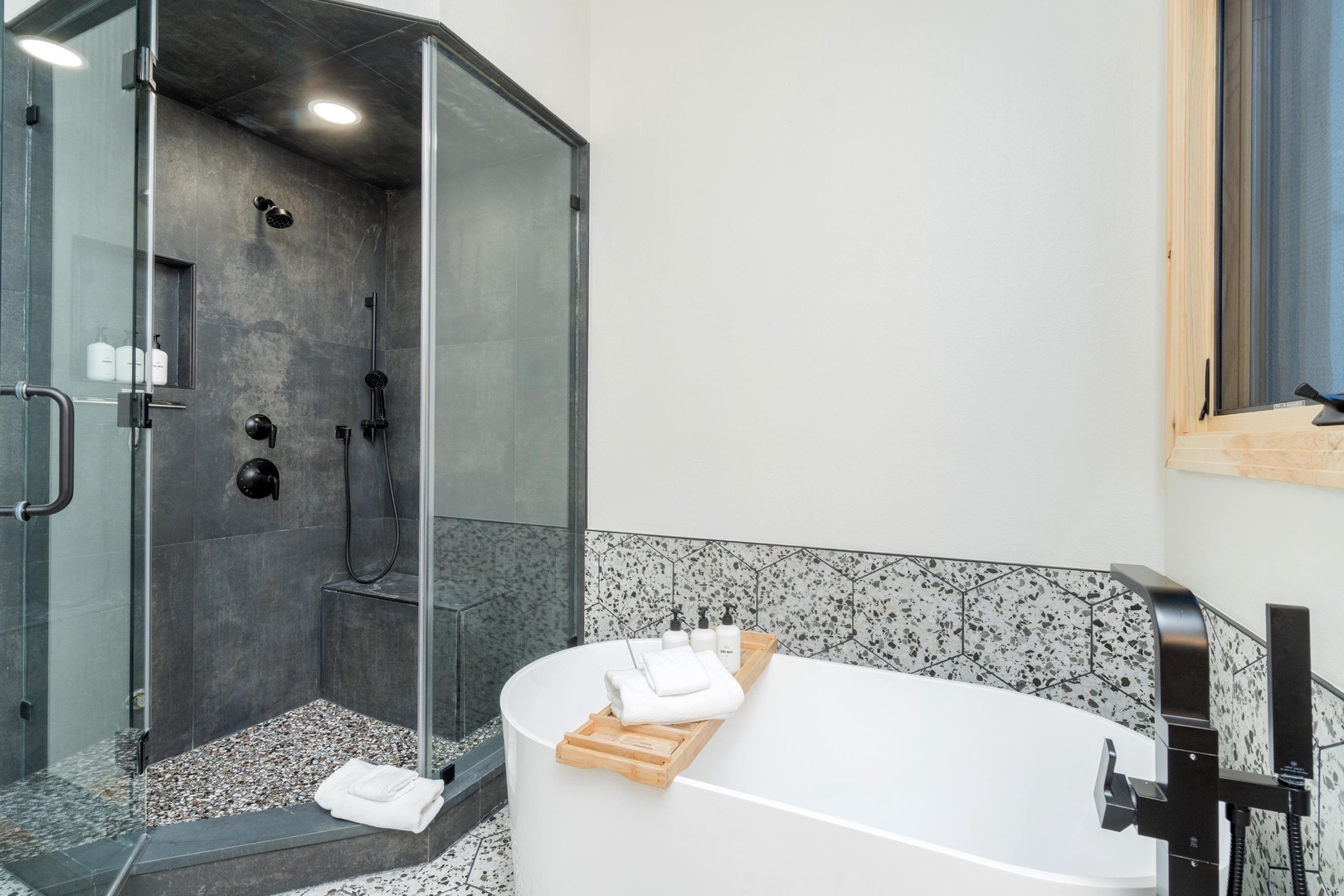 Unwind in your luxurious spa-like bathroom featuring a deep soaking tub and spacious glass-enclosed shower with premium fixtures and elegant stone accents.