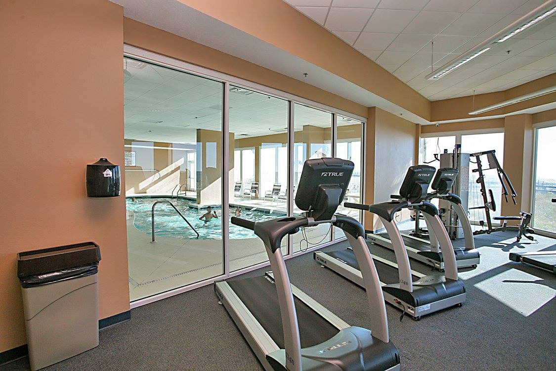 Fitness center with view of indoor pool