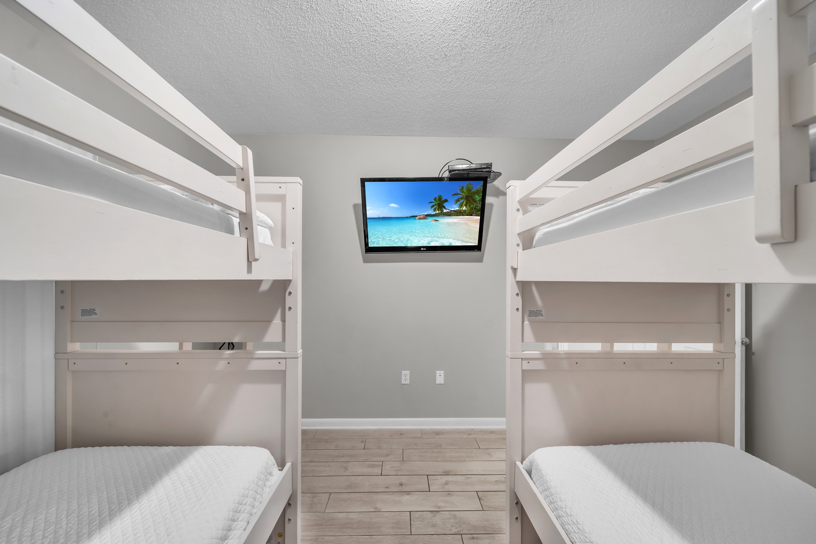 The second Guest Bedroom, a haven for the younger ones, features two sets of Bunk Beds with twin-size mattresses, accommodating an additional 4 people. This room also boasts a Large Flat-Screen HD TV and a DVD player