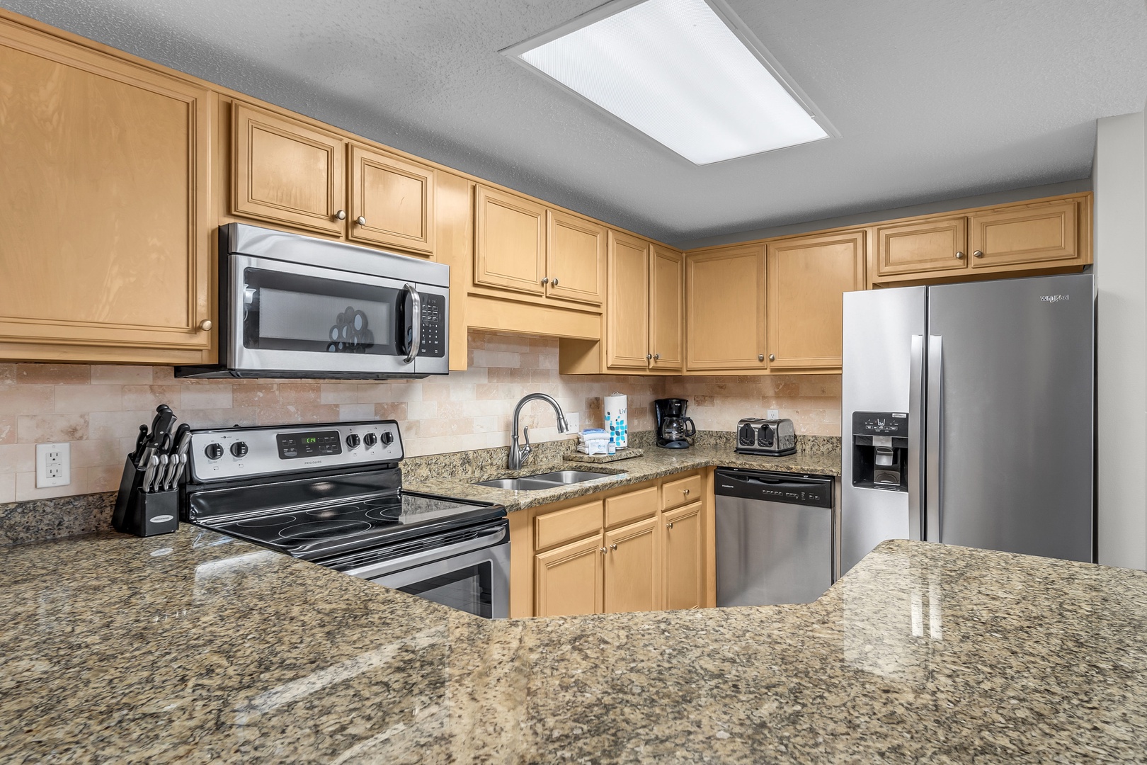 The large, fully stocked Kitchen boasts new Stainless appliances and Granite countertops, ensuring a perfect setting for culinary endeavors.