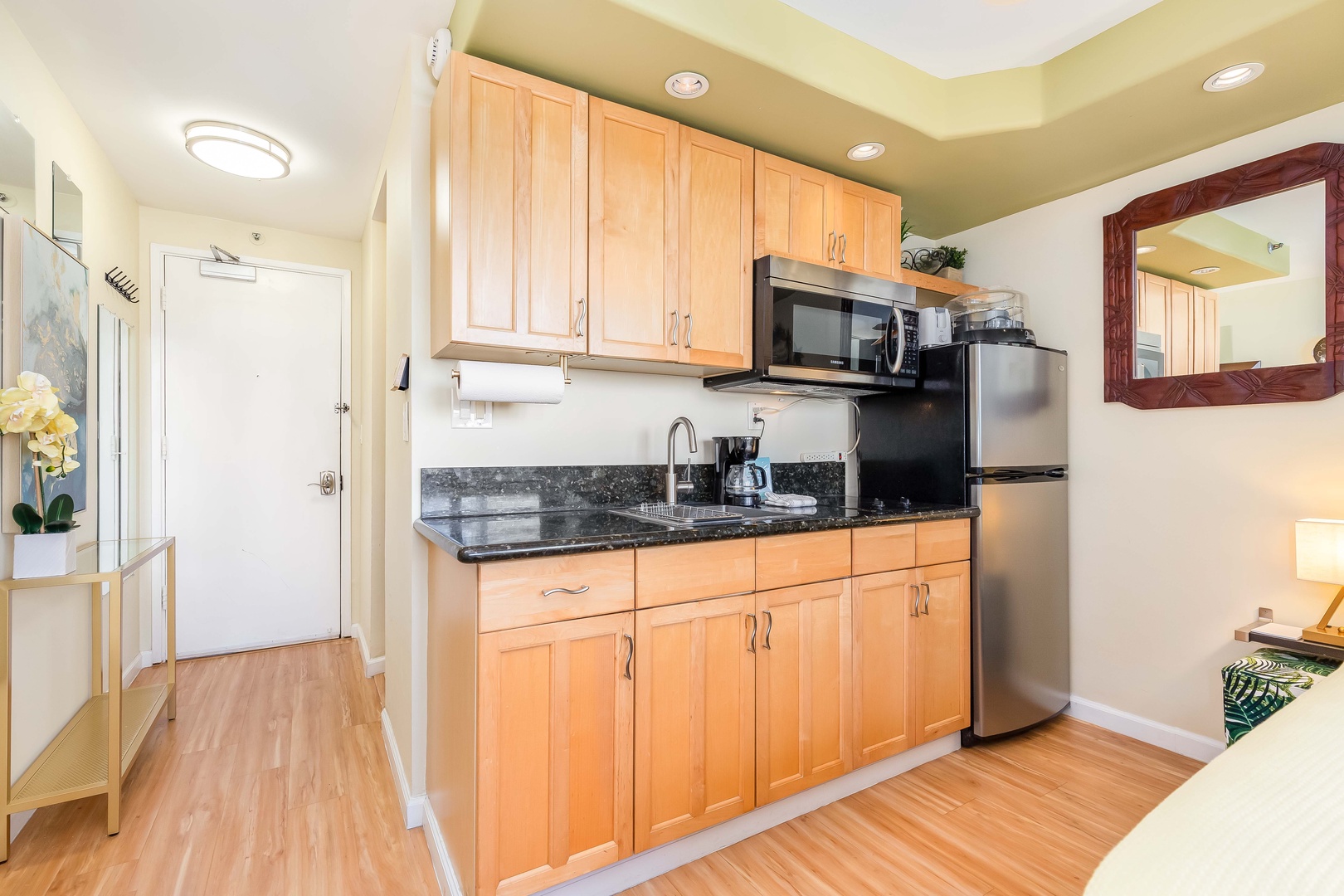 Your fully equipped kitchen invites you to prepare meals with ease, featuring granite countertops, modern appliances, and warm wood cabinetry that blends comfort with convenience.
