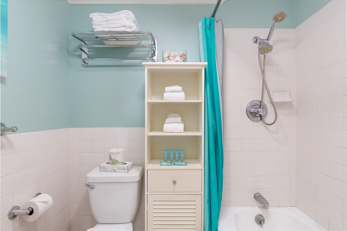 Relax in your spotless bathroom with soft towels, a refreshing dual-head shower, and cheerful turquoise accents that make each morning feel like a getaway.