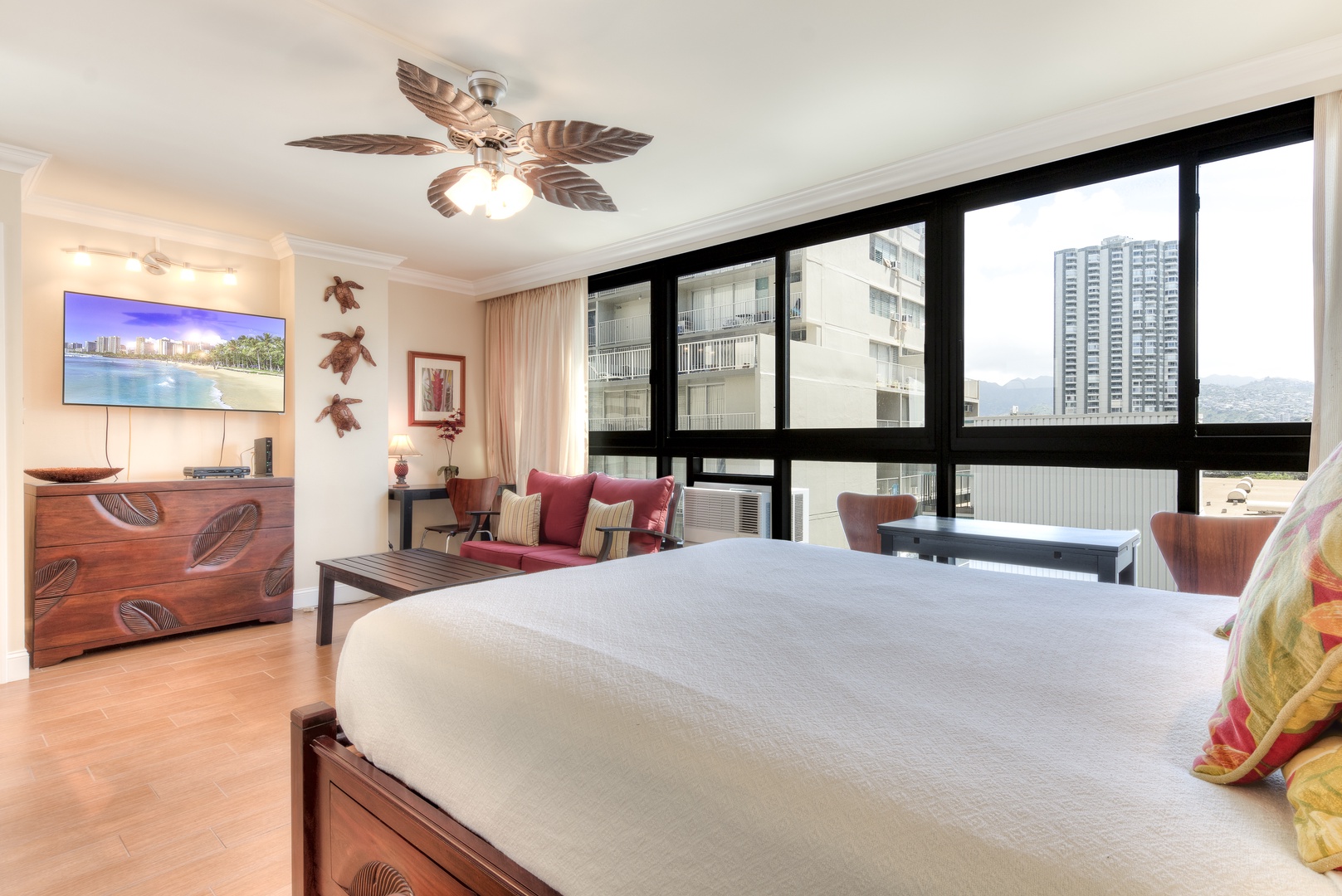 Wake up to sweeping city views from your sunlit bedroom, where tropical-inspired décor and a cozy seating nook invite you to relax in island-style comfort.