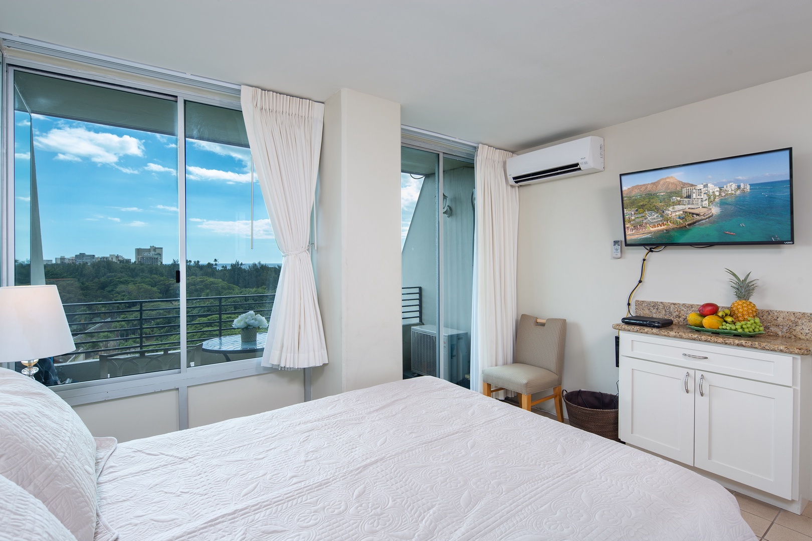 Wake up to ocean views framed by floor-to-ceiling windows. Your private balcony invites morning coffee as gentle breezes cool the air. Every detail, from plush bedding to fresh tropical fruit, welcomes you home.