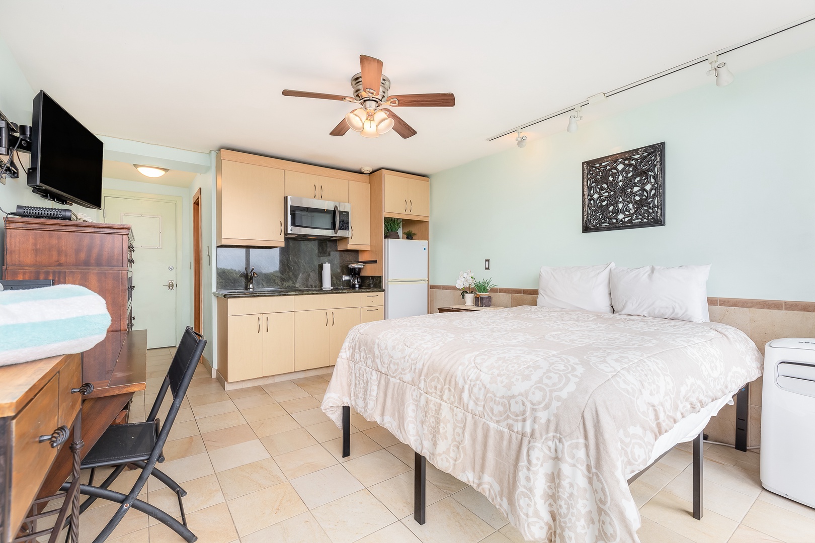 Your comfortable studio blends sleeping, cooking, and living spaces with soft linens, a full kitchen, and a ceiling fan for a relaxing stay.