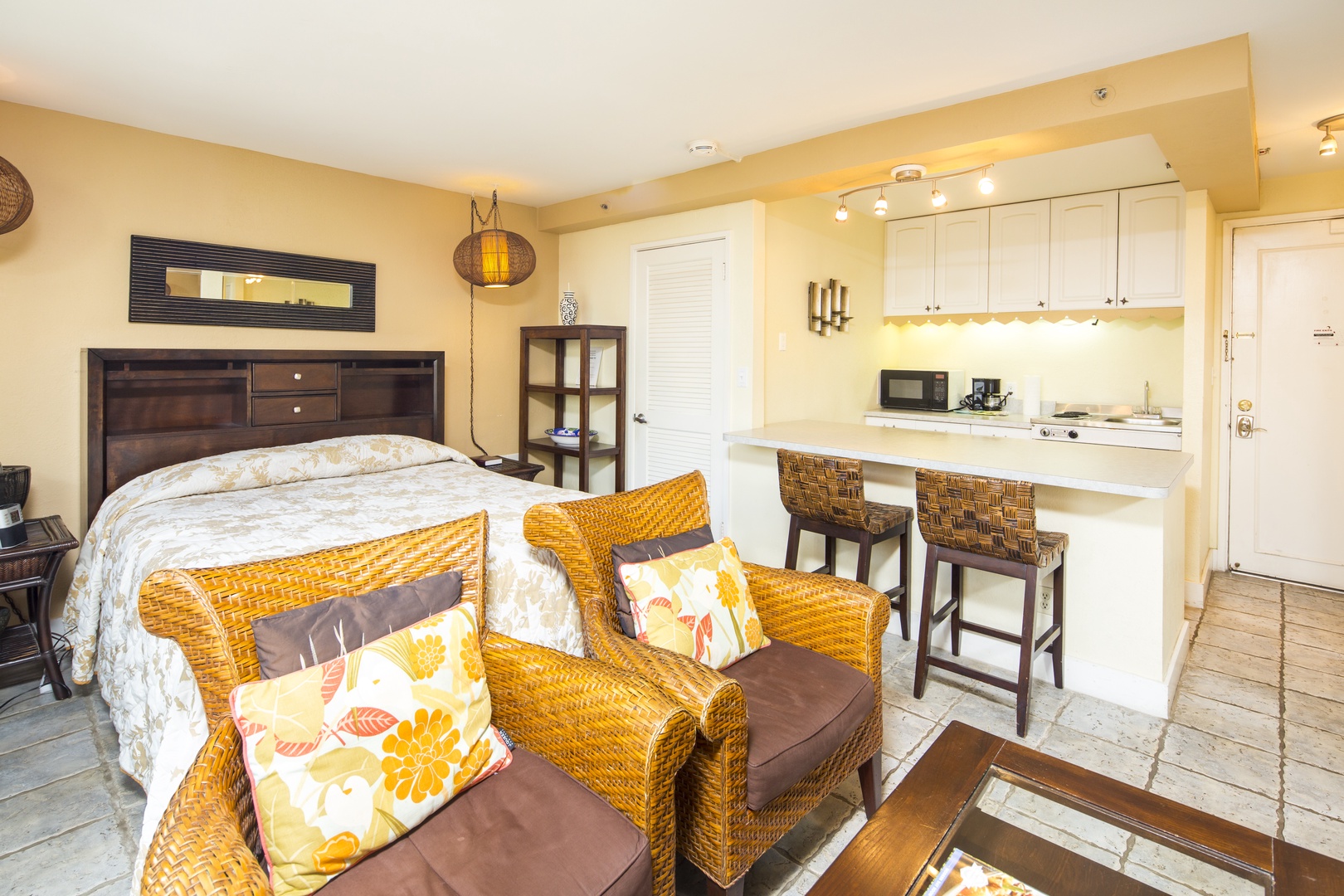 Relax in your cozy studio with a comfy bed, wicker seating, and a sleek kitchenette ready for your morning coffee or snacks.