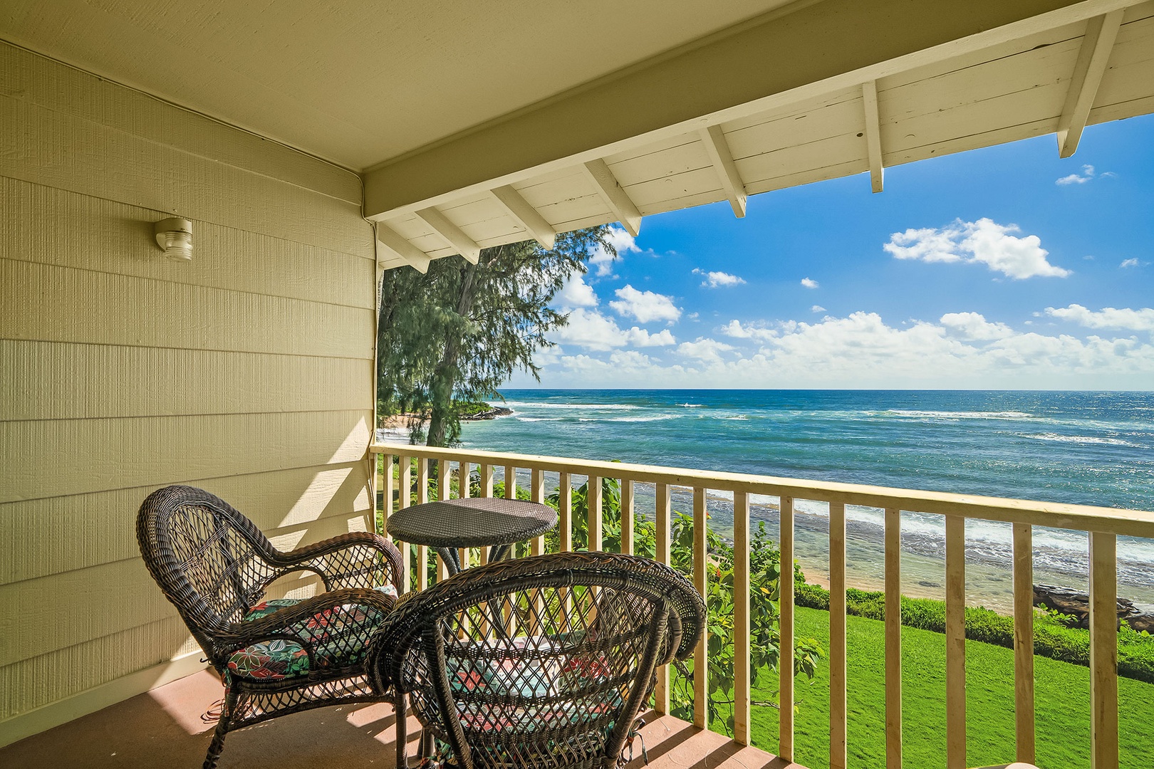 Your private oceanfront balcony offers front-row seats to endless azure waters and rolling waves, with cozy wicker seating perfect for morning coffee or sunset cocktails.