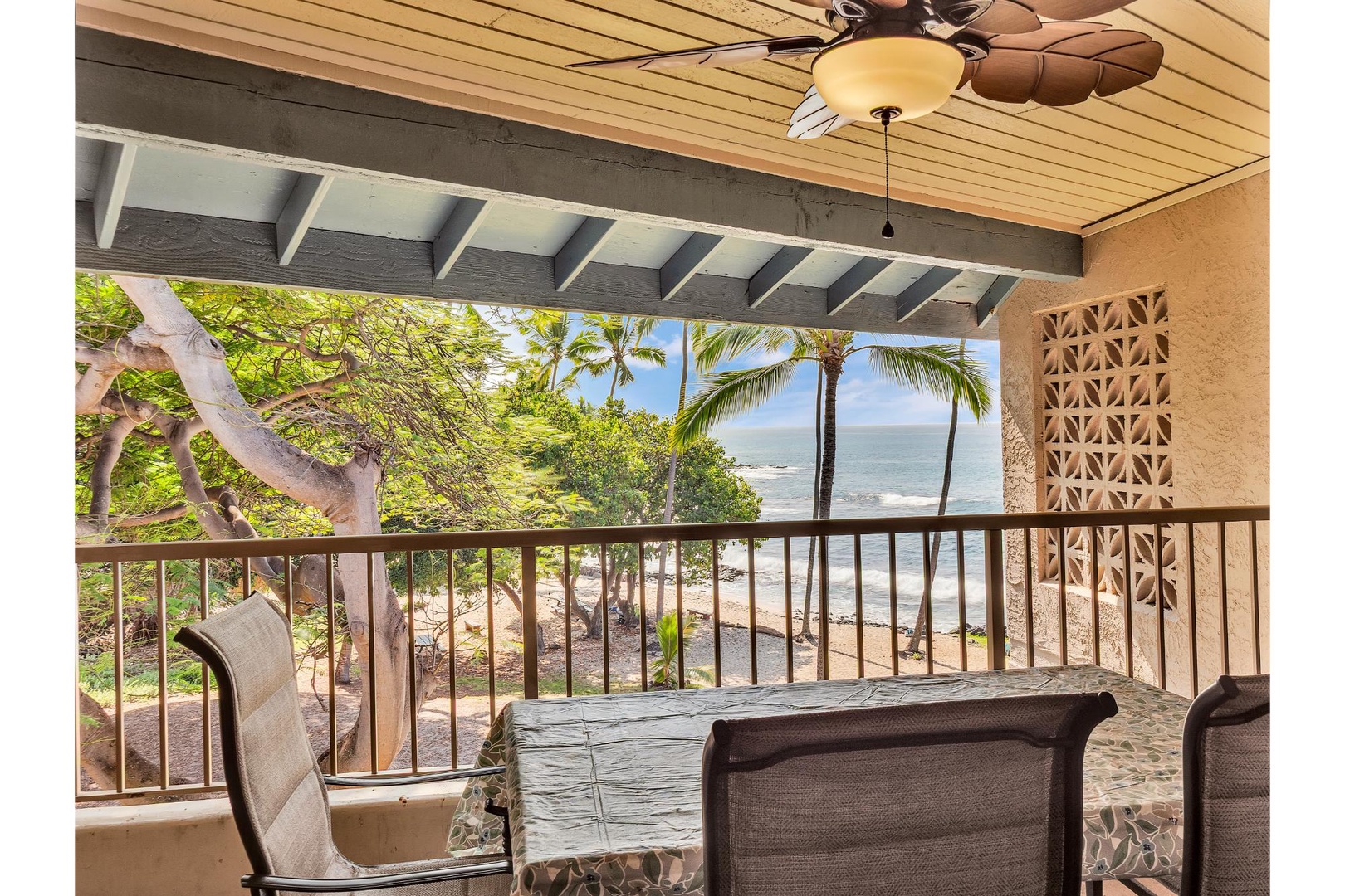 Your private balcony offers stunning ocean views with tropical palms and sandy beach below—the perfect spot to savor morning coffee.