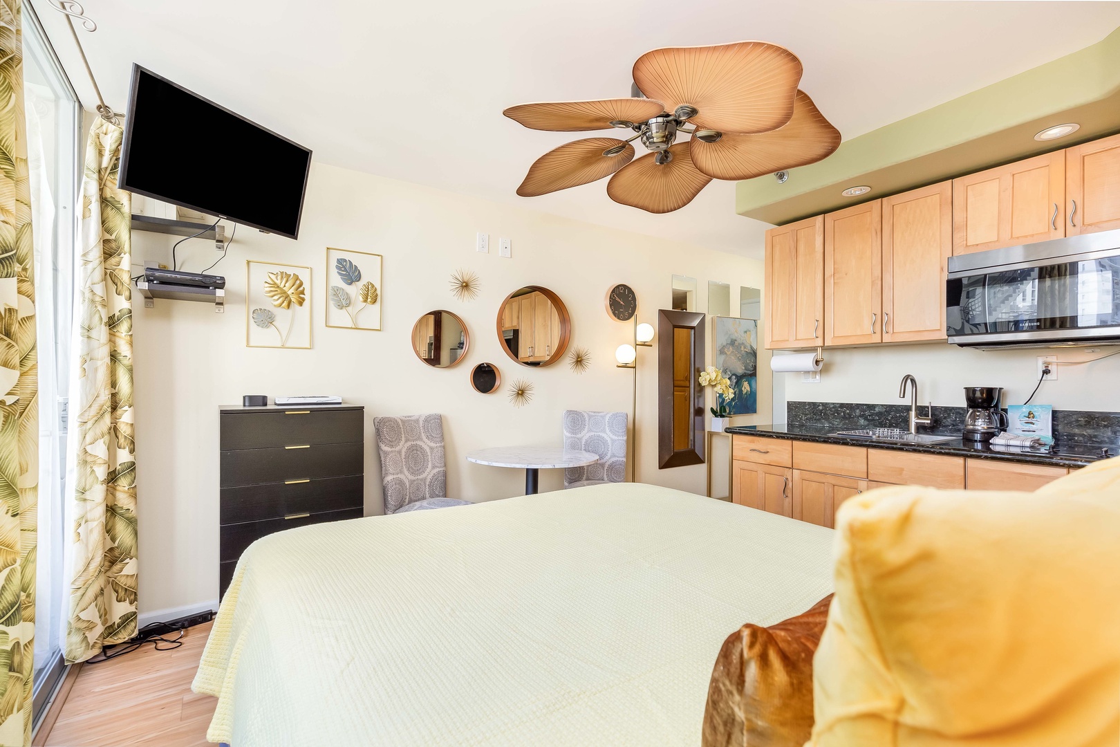 Your bright studio blends comfort and convenience with a cozy bed, fully-equipped kitchenette, tropical ceiling fan, and wall-mounted TV—perfect for unwinding after exploring nearby attractions.