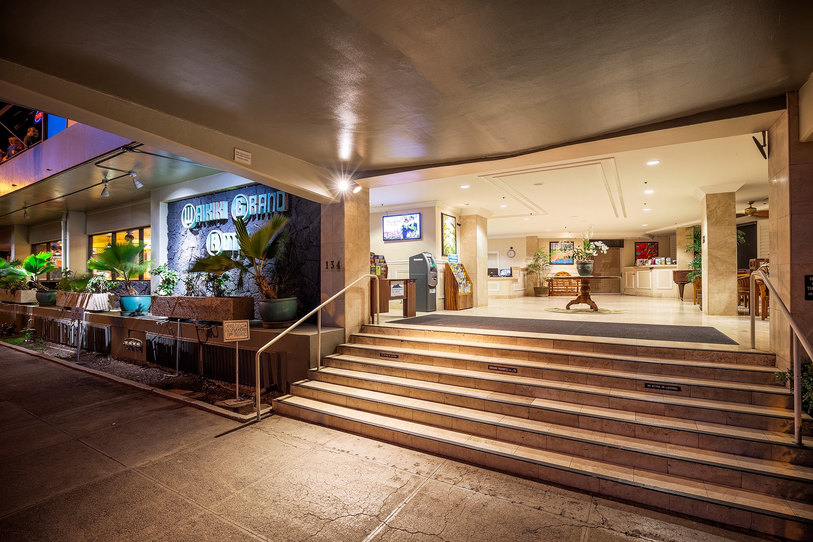This vibrant lobby entrance welcomes guests with modern design, lush greenery, and warm lighting—your gateway to a comfortable stay in a thoughtfully designed space.