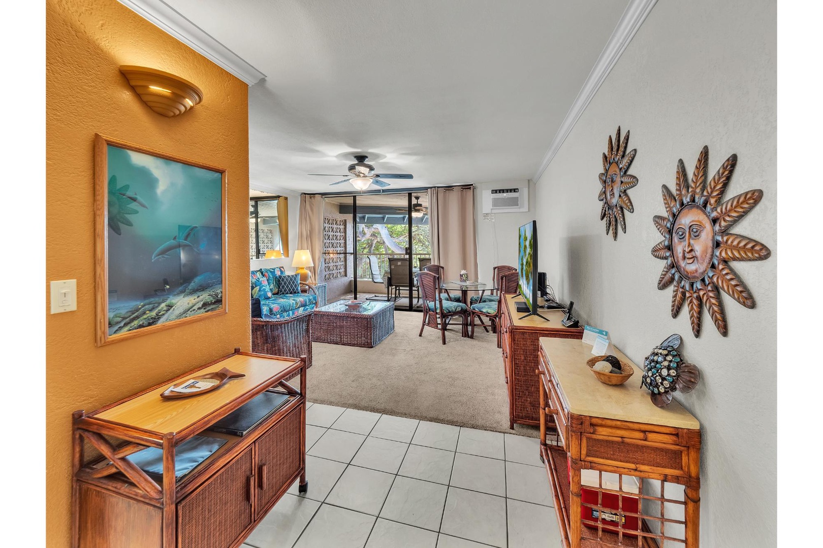 Relax in your tropical-themed living space with ocean artwork, wicker furniture, and a private balcony perfect for unwinding after island adventures.