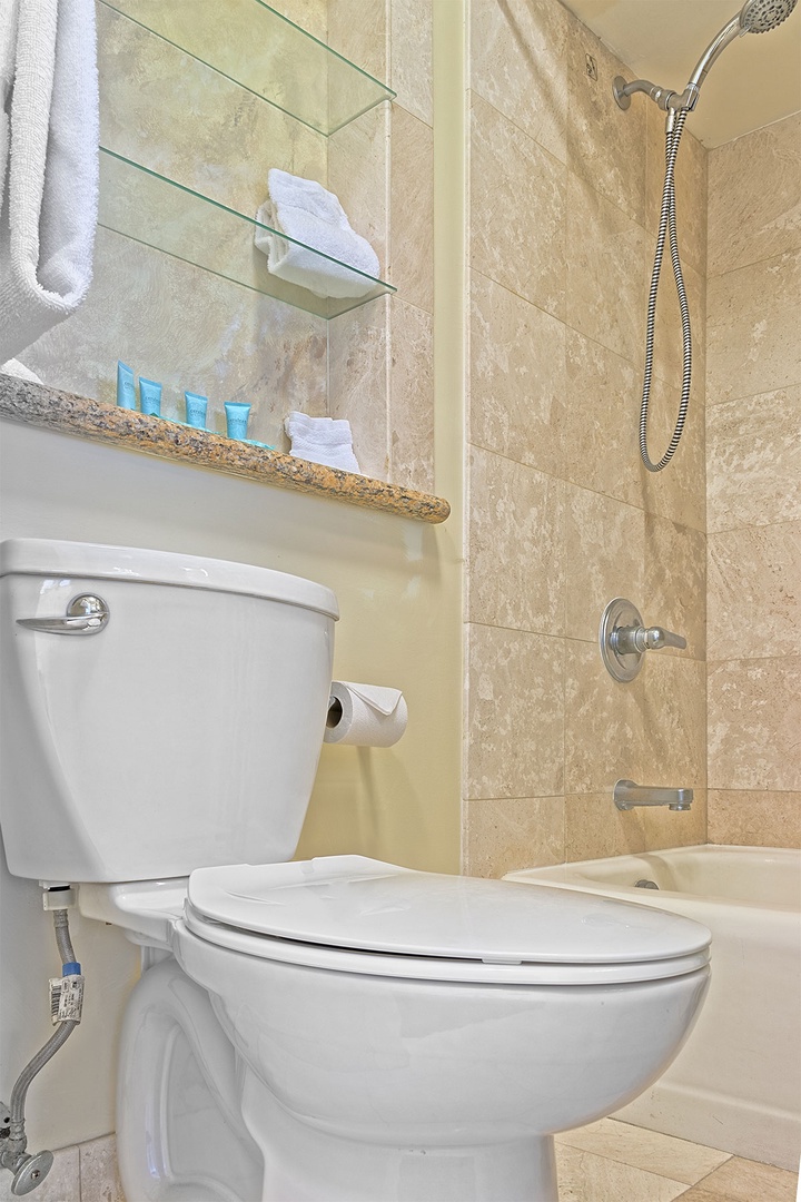 Freshen up after your beach adventures in this well-appointed bathroom with a handheld showerhead, crisp linens, and complimentary toiletries ready for your use.