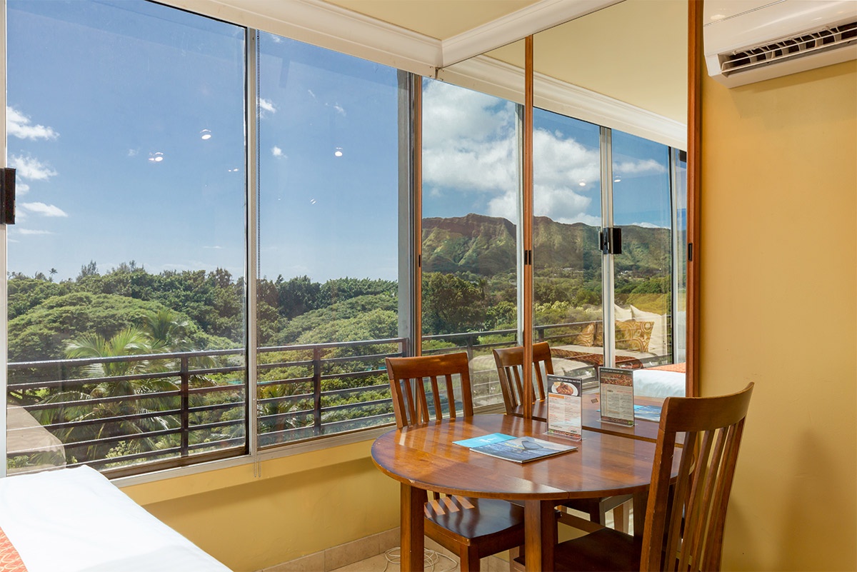 Sip your morning coffee at this cozy table while soaking in stunning mountain views through floor-to-ceiling windows—your peaceful retreat awaits.