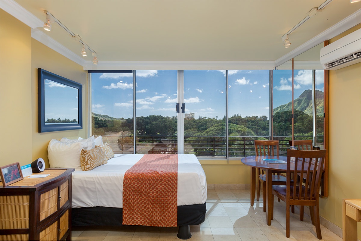 Wake up to breathtaking mountain views through floor-to-ceiling windows. Your cozy retreat features a plush bed, a dining nook, and serene natural light that fills the space throughout the day.