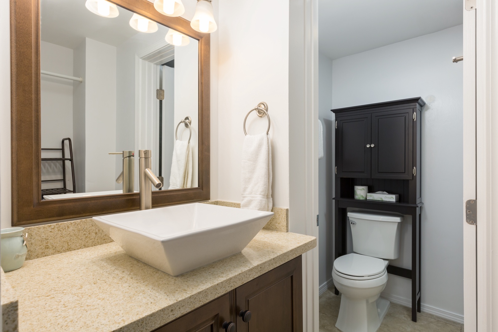Your private bathroom features a modern vessel sink, warm wood accents, and ample storage—everything you need to feel refreshed and at home.