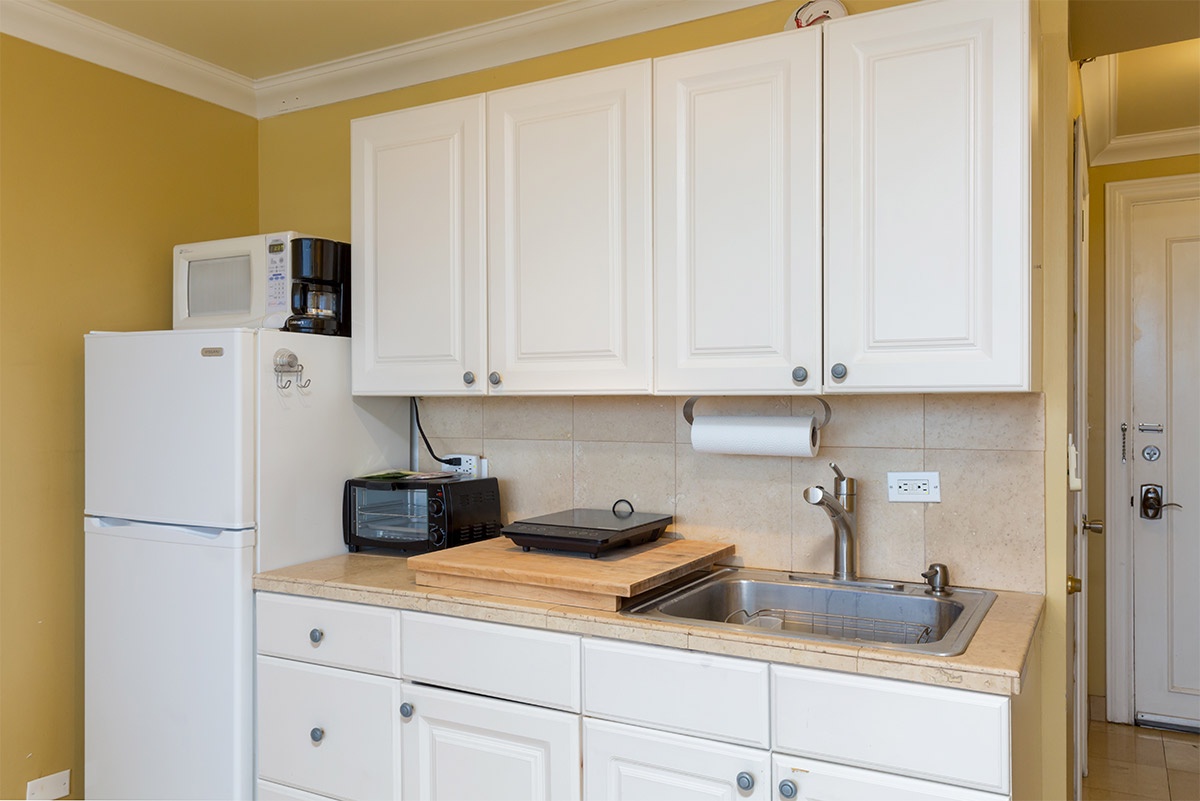 Your fully equipped kitchenette features crisp white cabinetry, a refrigerator, microwave, coffee maker, and everything you need to prepare light meals during your stay.