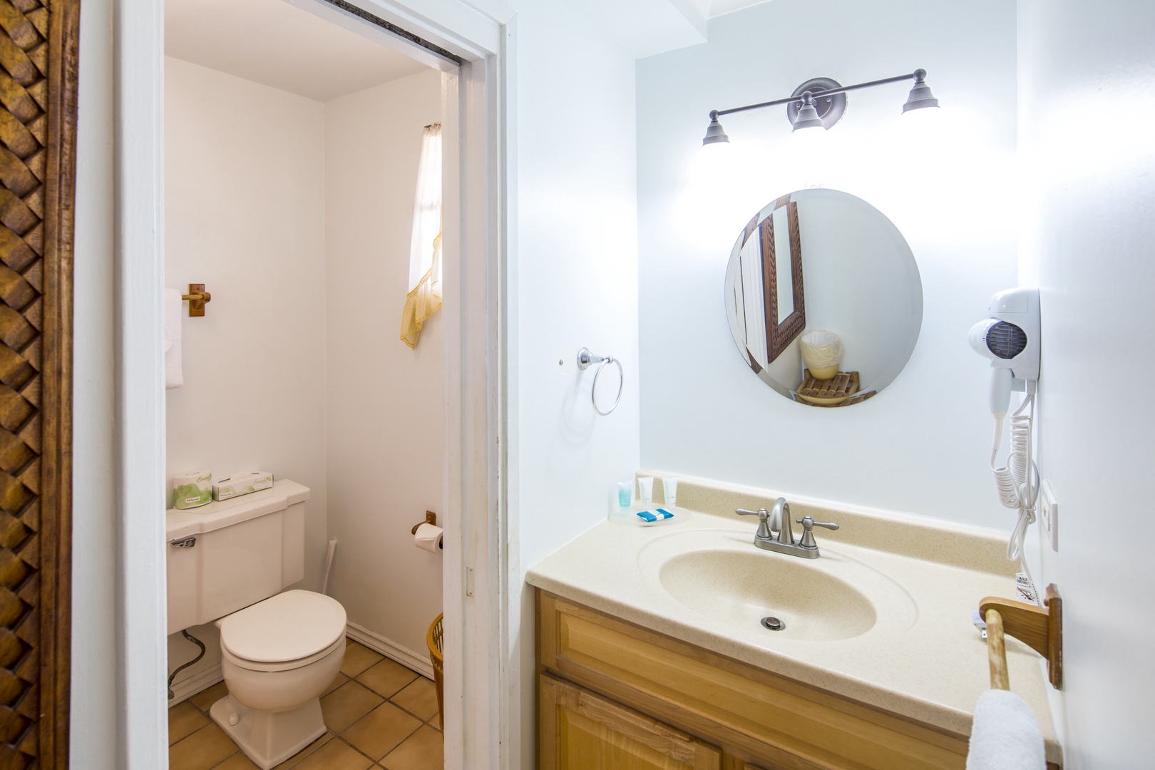 Your private bathroom features a warm vanity, round mirror, and fresh amenities, with a separate shower area for your comfort and convenience.