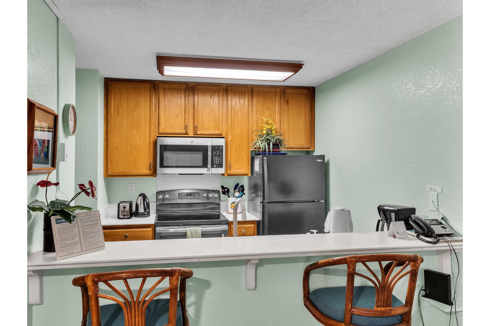 Your fully equipped kitchen features warm wood cabinets, modern appliances, and a breakfast bar perfect for morning coffee or quick meals.