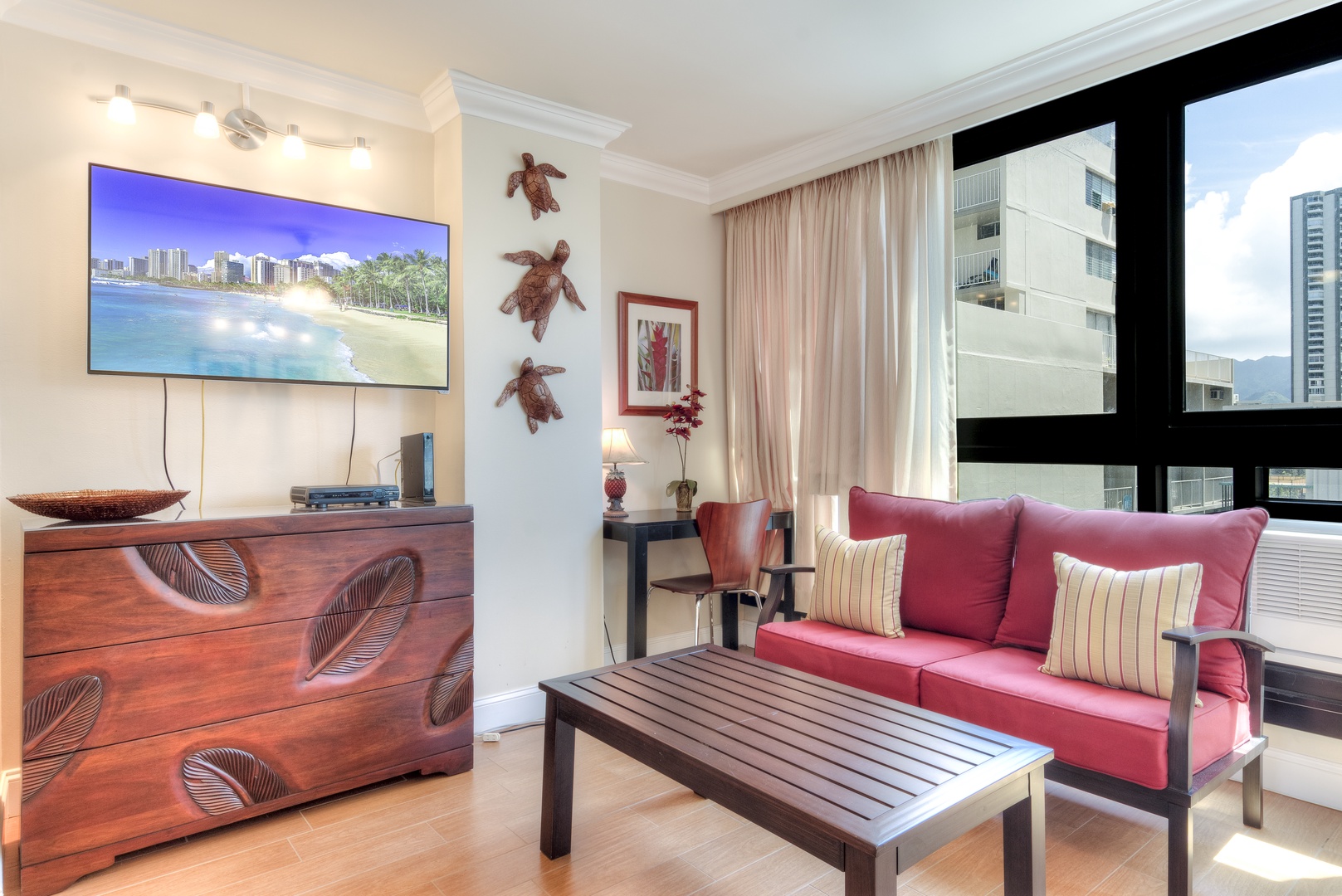 Relax in your bright living space with tropical touches, modern amenities, and natural light streaming through floor-to-ceiling windows overlooking the city skyline.